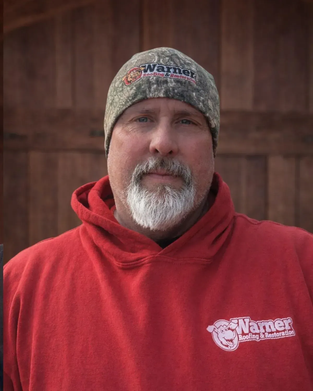 A man wearing a camo beanie and red hoodie with the