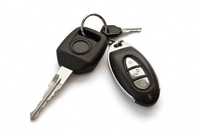 Un par de llaves de coche y un mando a distancia sobre un fondo blanco.