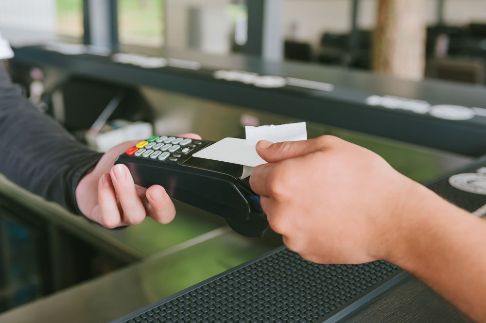 Pagamento manual com cartão em um terminal de pagamento com leitor de cartão sem contato.