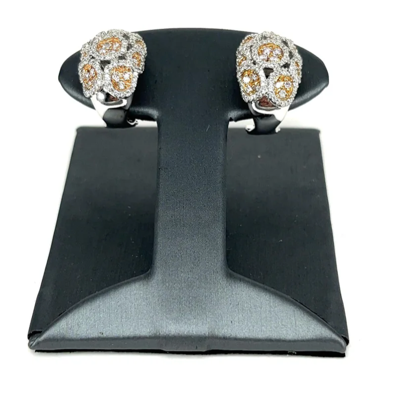 A pair of earrings are sitting on a black display stand