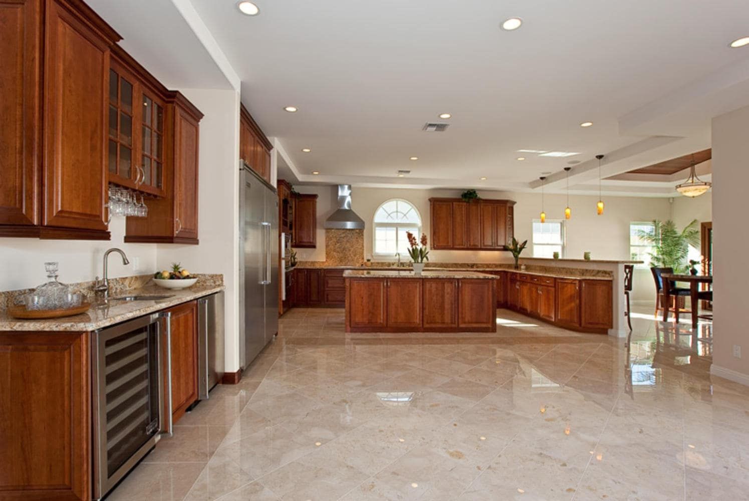 Spacious kitchen with wood cabinets, stainless steel appliances, granite countertops, and tile floors.