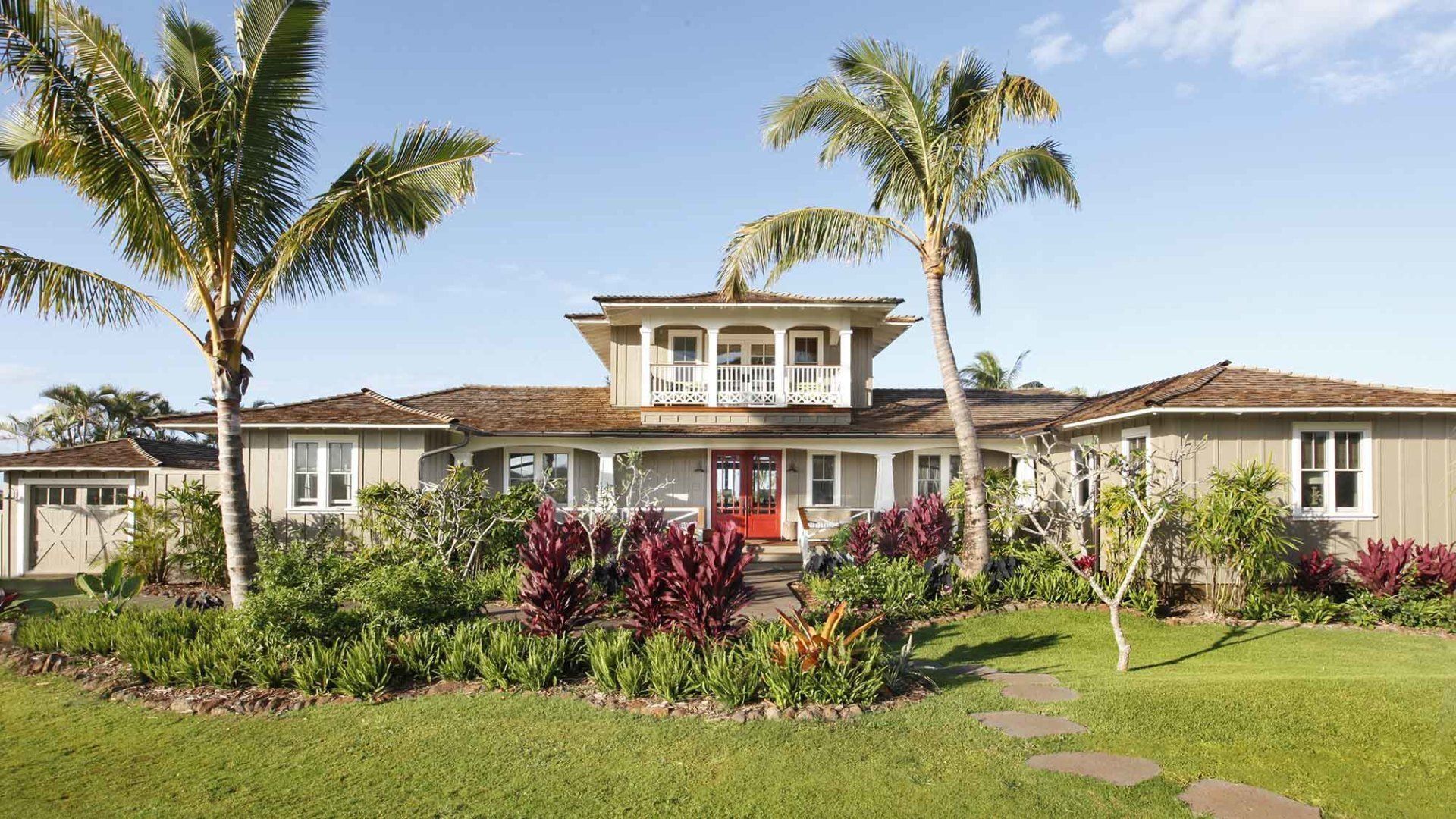 Tropical home with palm trees and red front door.