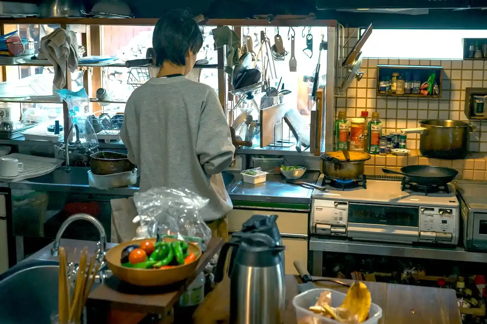 A person preparing seasonal produce in a rustic kitchen, reflecting the patience and natural rhythm 