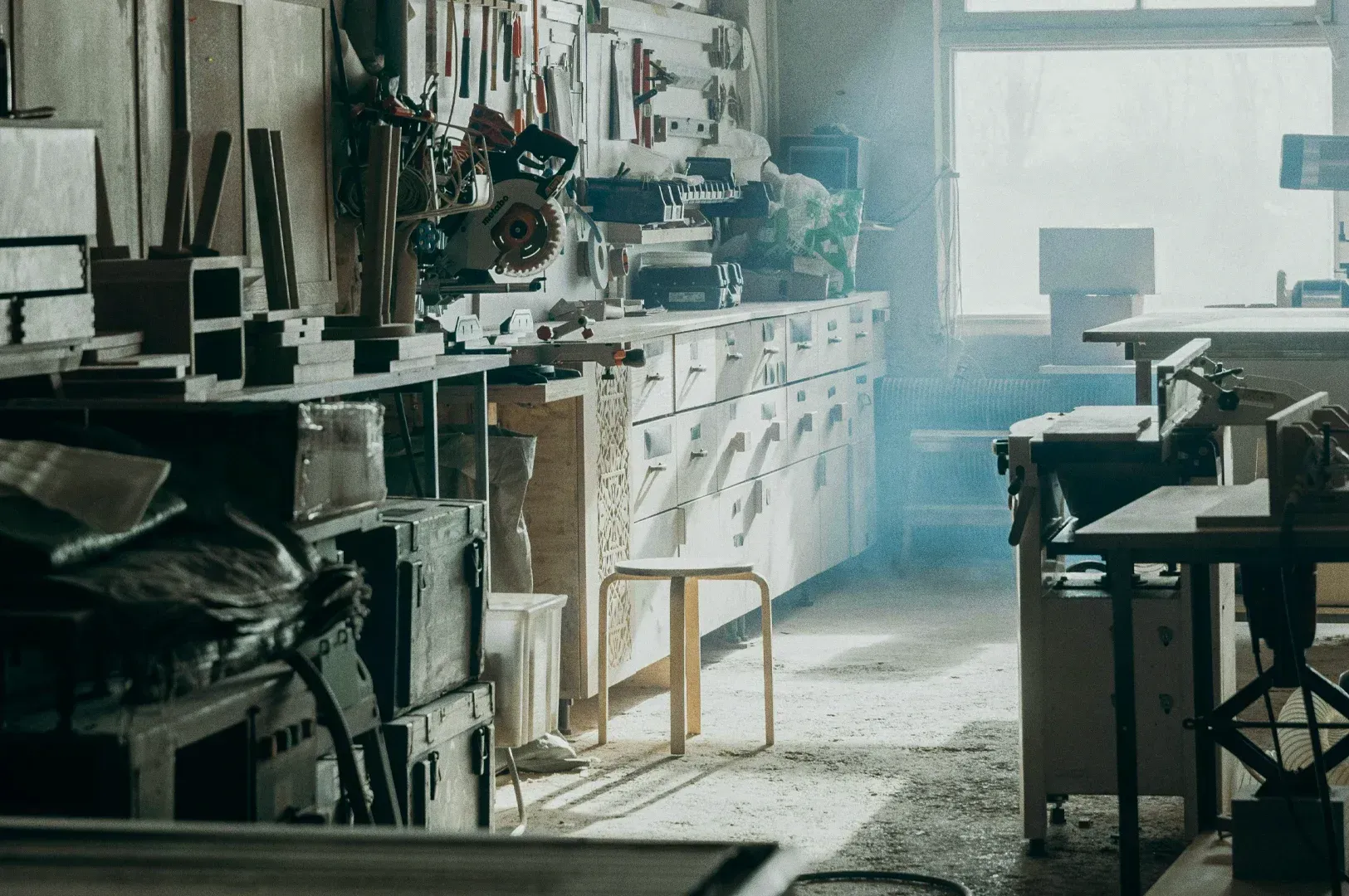Sunlit woodworking workshop with organized tools, saws, and workbench furniture in a carpenter studi