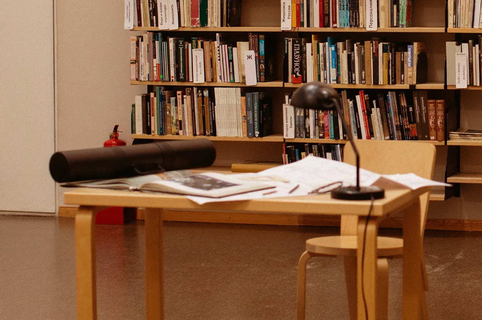 A focused workspace in a library setting, featuring a desk with research documents and a lamp, designed for deep concentration and intentional creative habits.