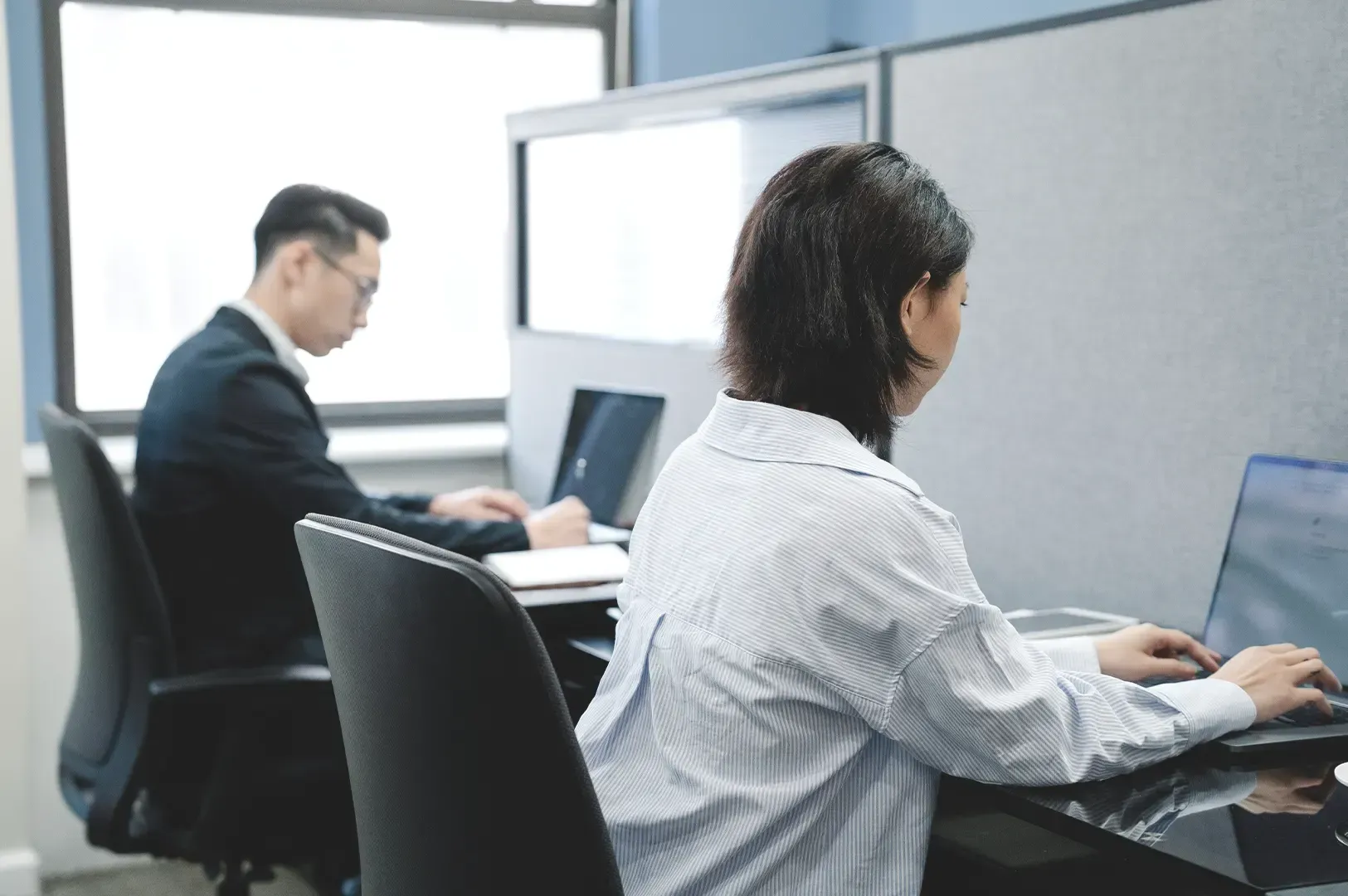 Professionals focused on individual tasks in an office setting, representing the quiet grace of becoming more specific and focused rather than louder with age.