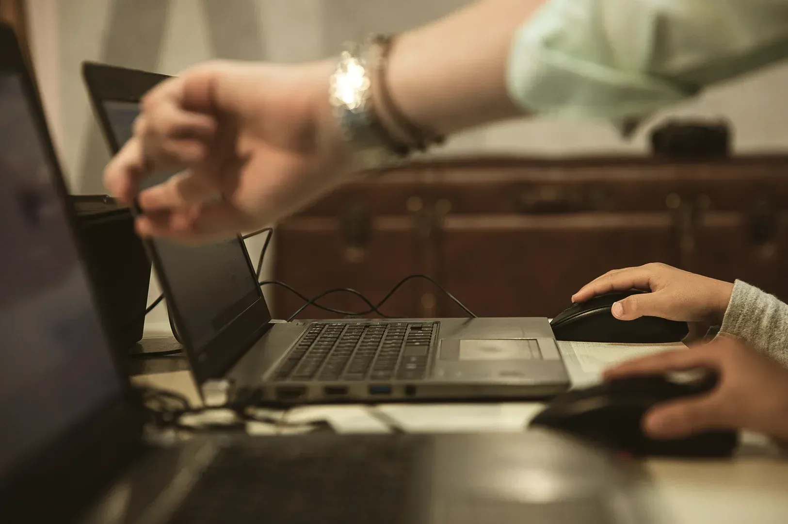 Two people working closely side by side on laptops, highlighting collaborative mentorship and professional development.