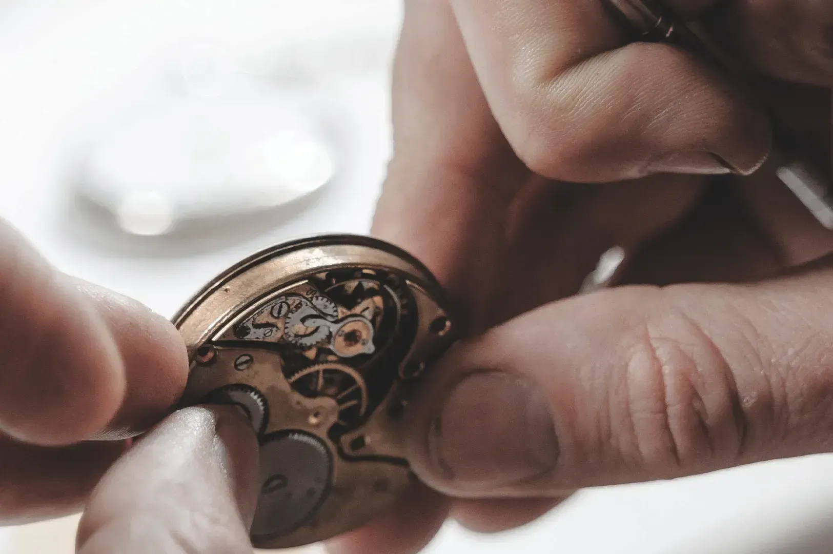 Macro shot of hands meticulously repairing the intricate gears of a vintage pocket watch movement with a precision screwdriver, highlighting repair as a meaningful relationship with time.
