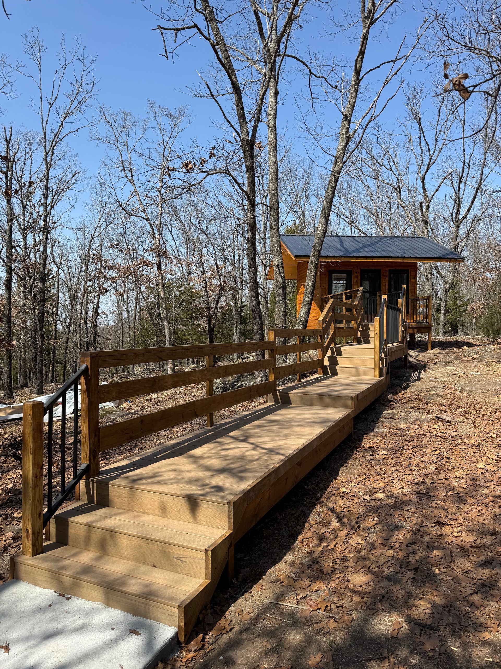 A wooden walkway leading to a cabin in the woods.