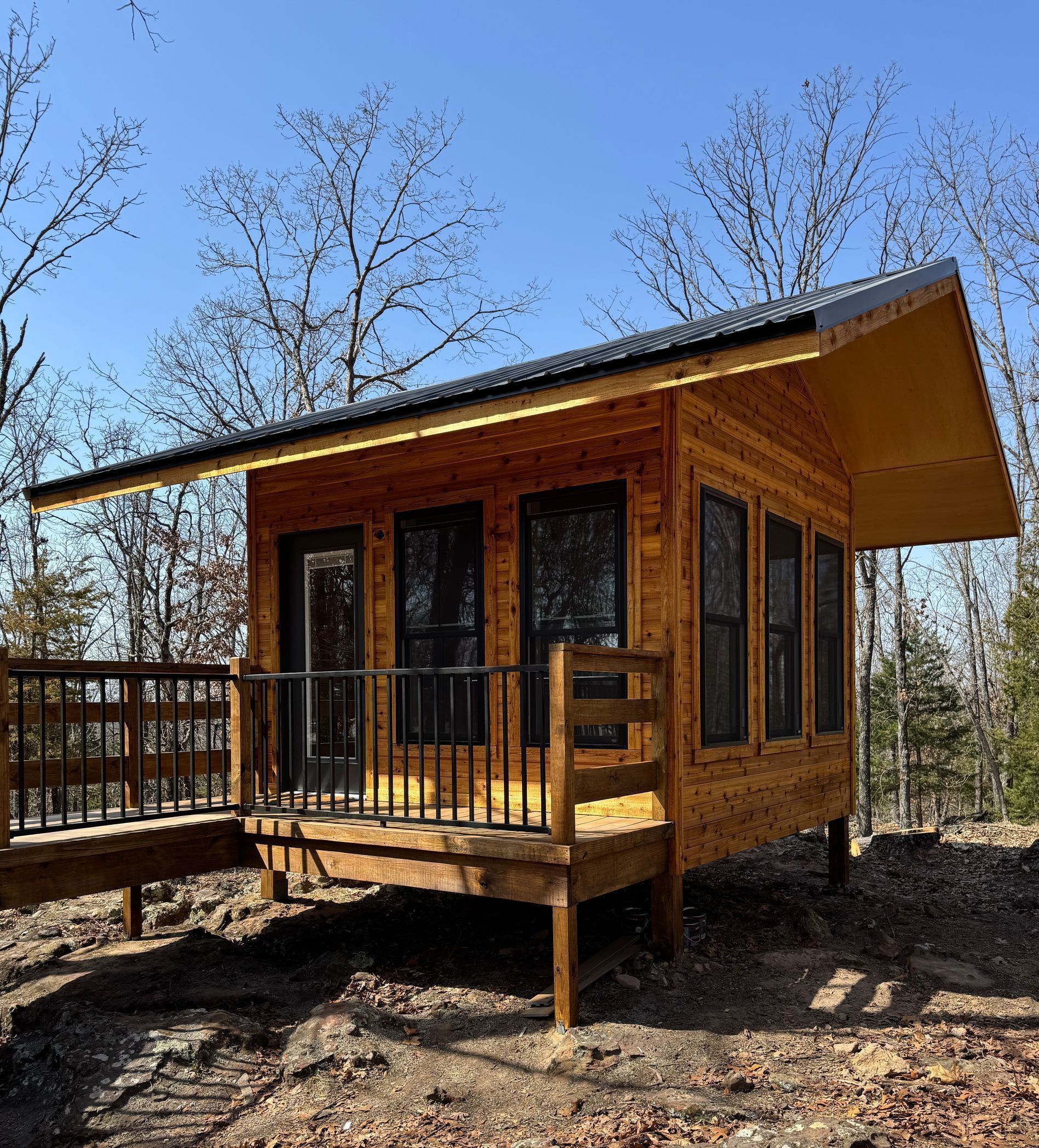A small wooden cabin with a balcony in the woods