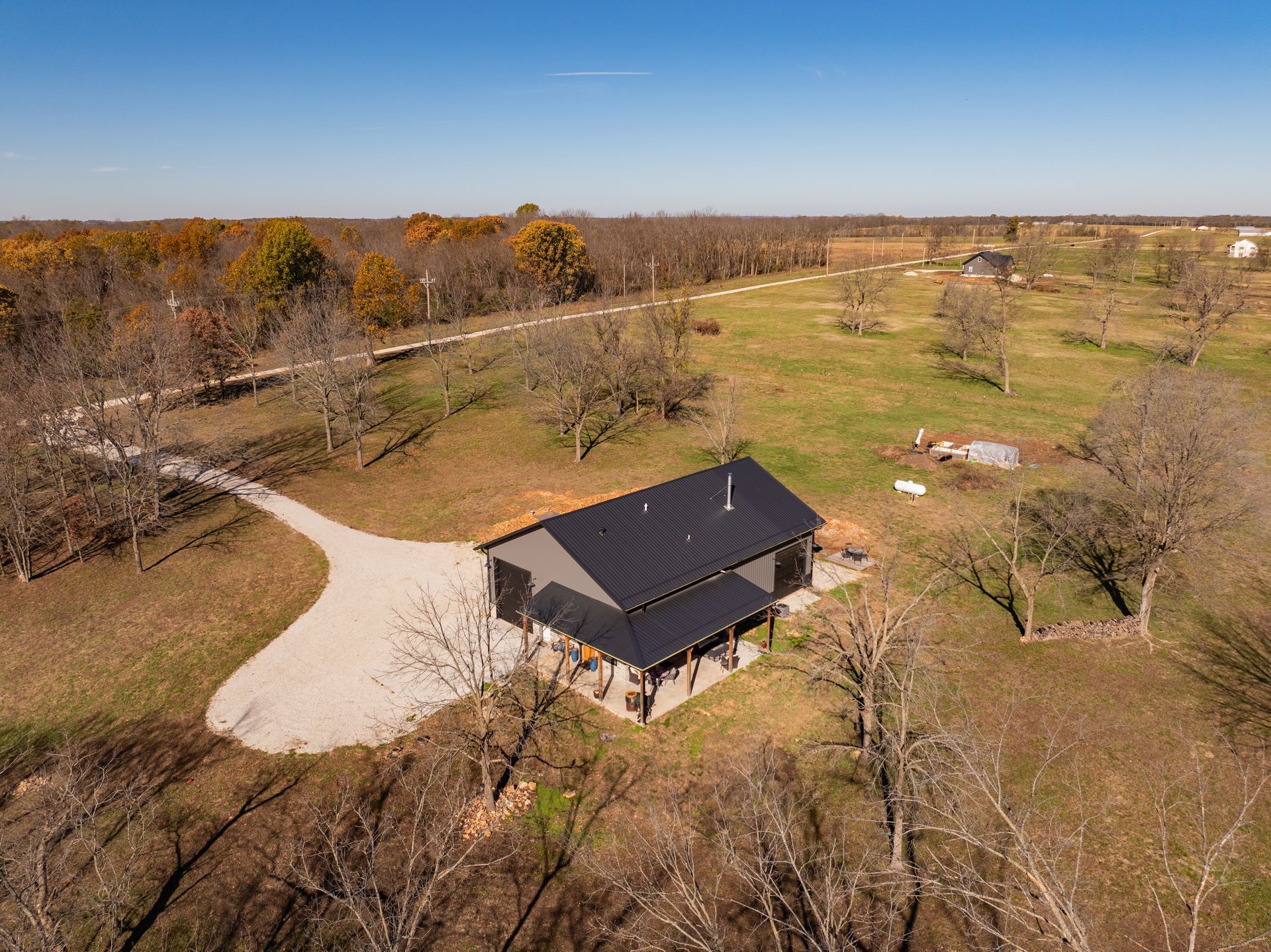 An aerial view of a house in the middle of a field.