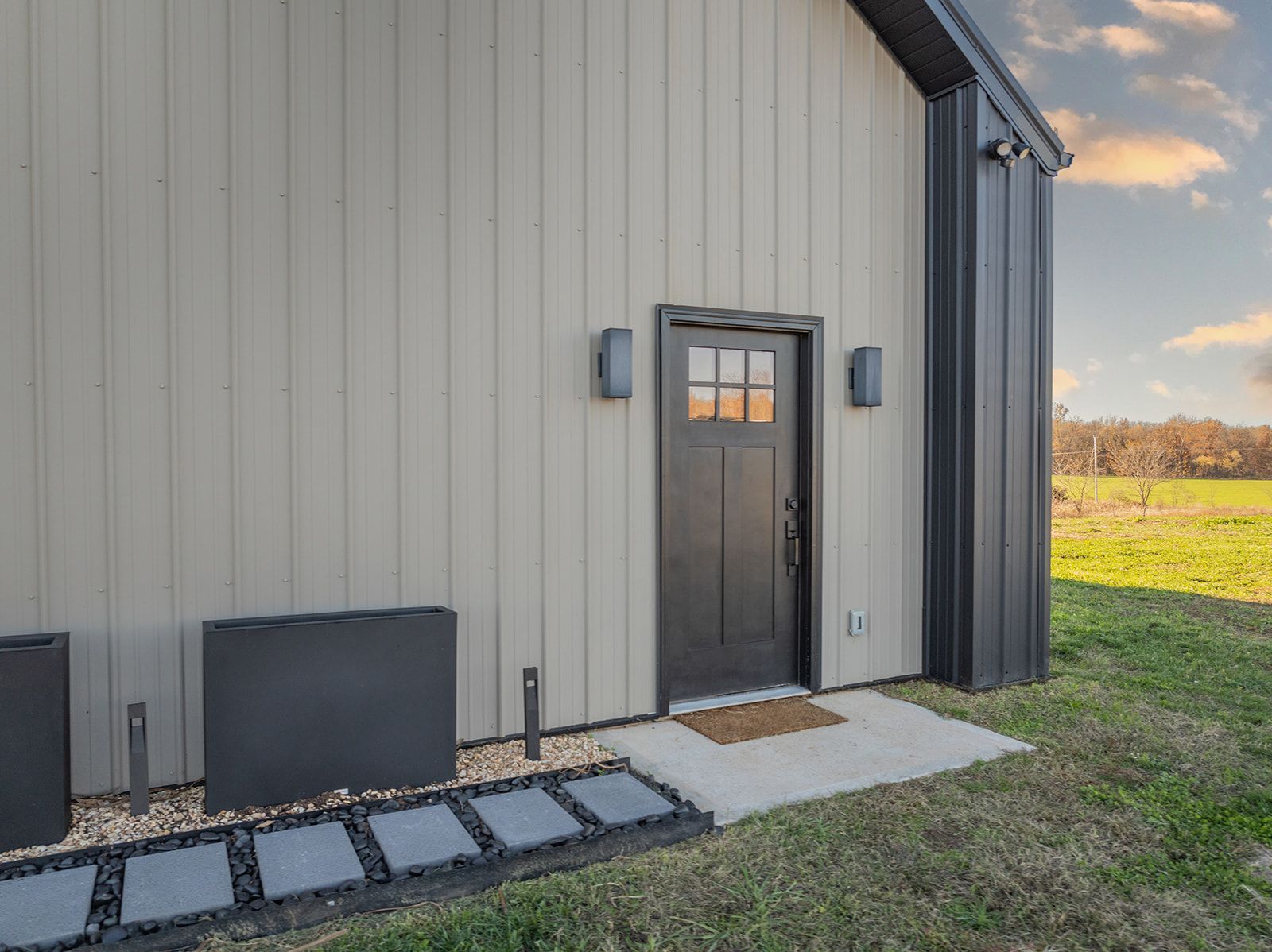 A house with a black door and a walkway leading to it.