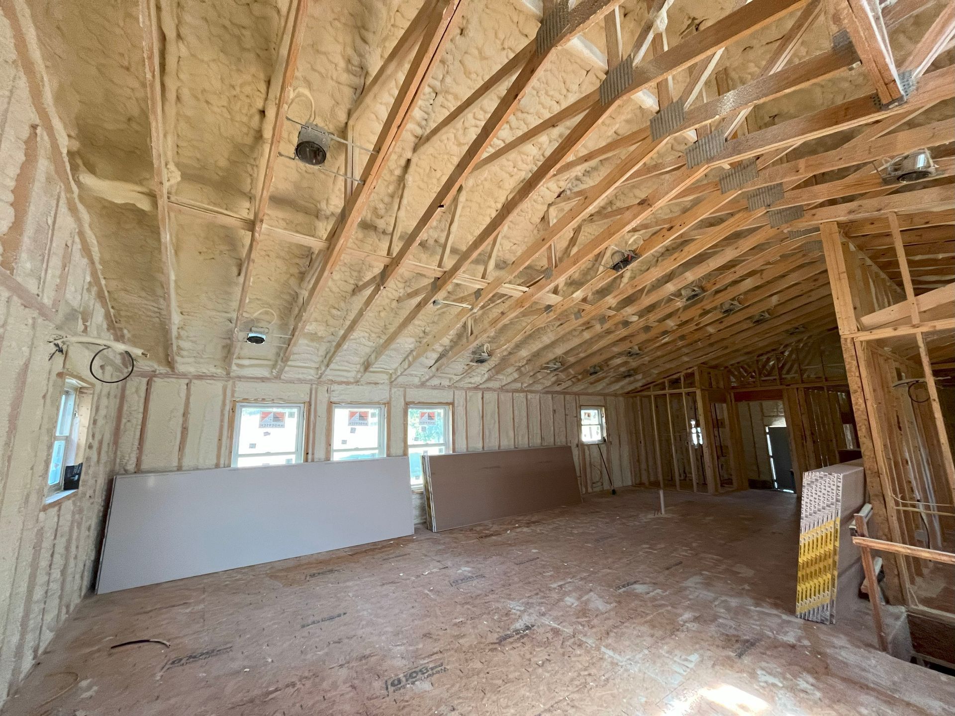 The inside of a building under construction with a lot of insulation on the ceiling.