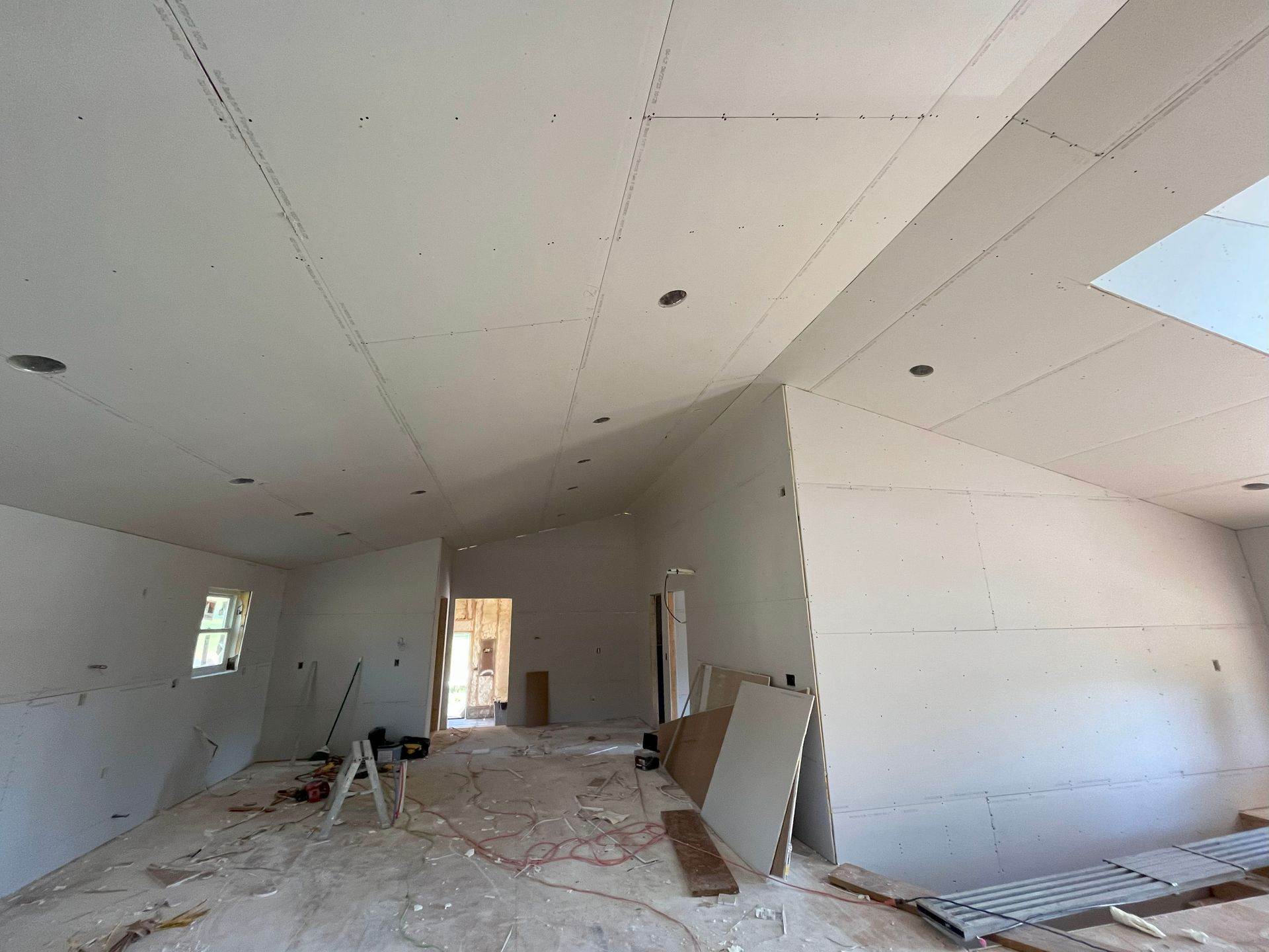 A large room with a vaulted ceiling is being remodeled.