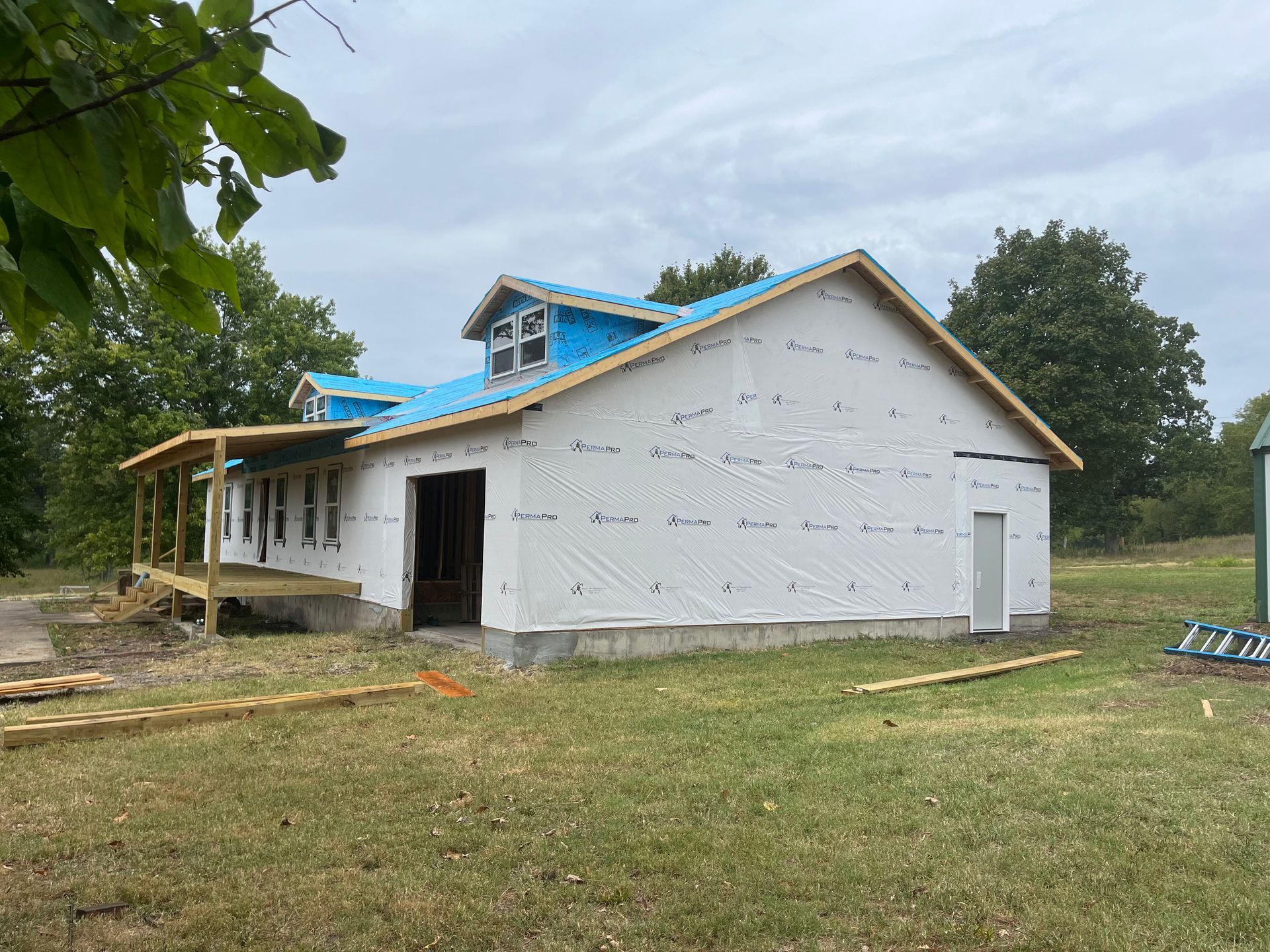 A house is being built in the middle of a grassy field.