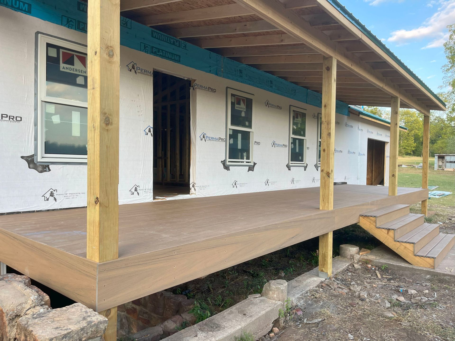 A house under construction with a porch and stairs
