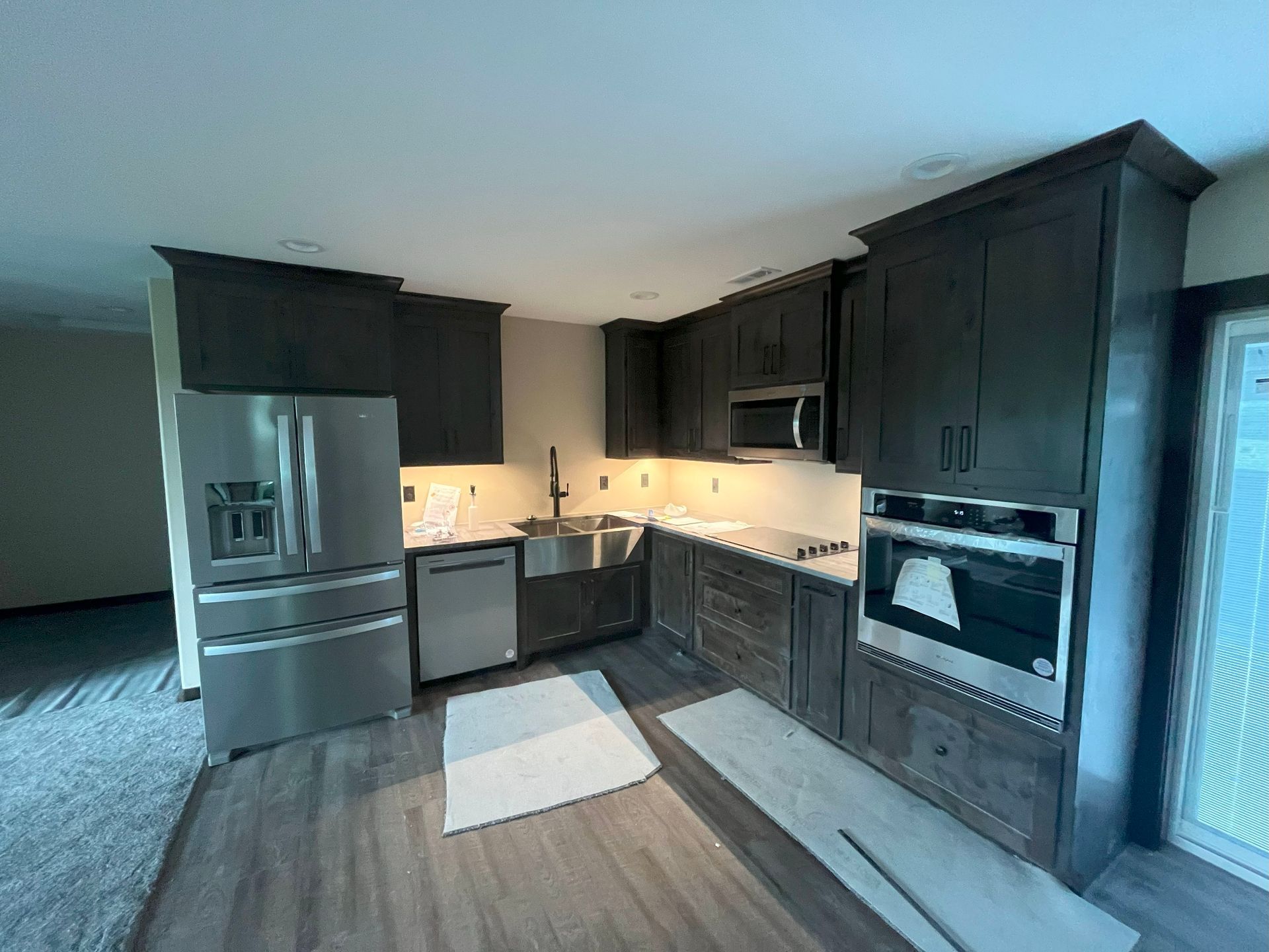 A kitchen with stainless steel appliances and wooden cabinets.