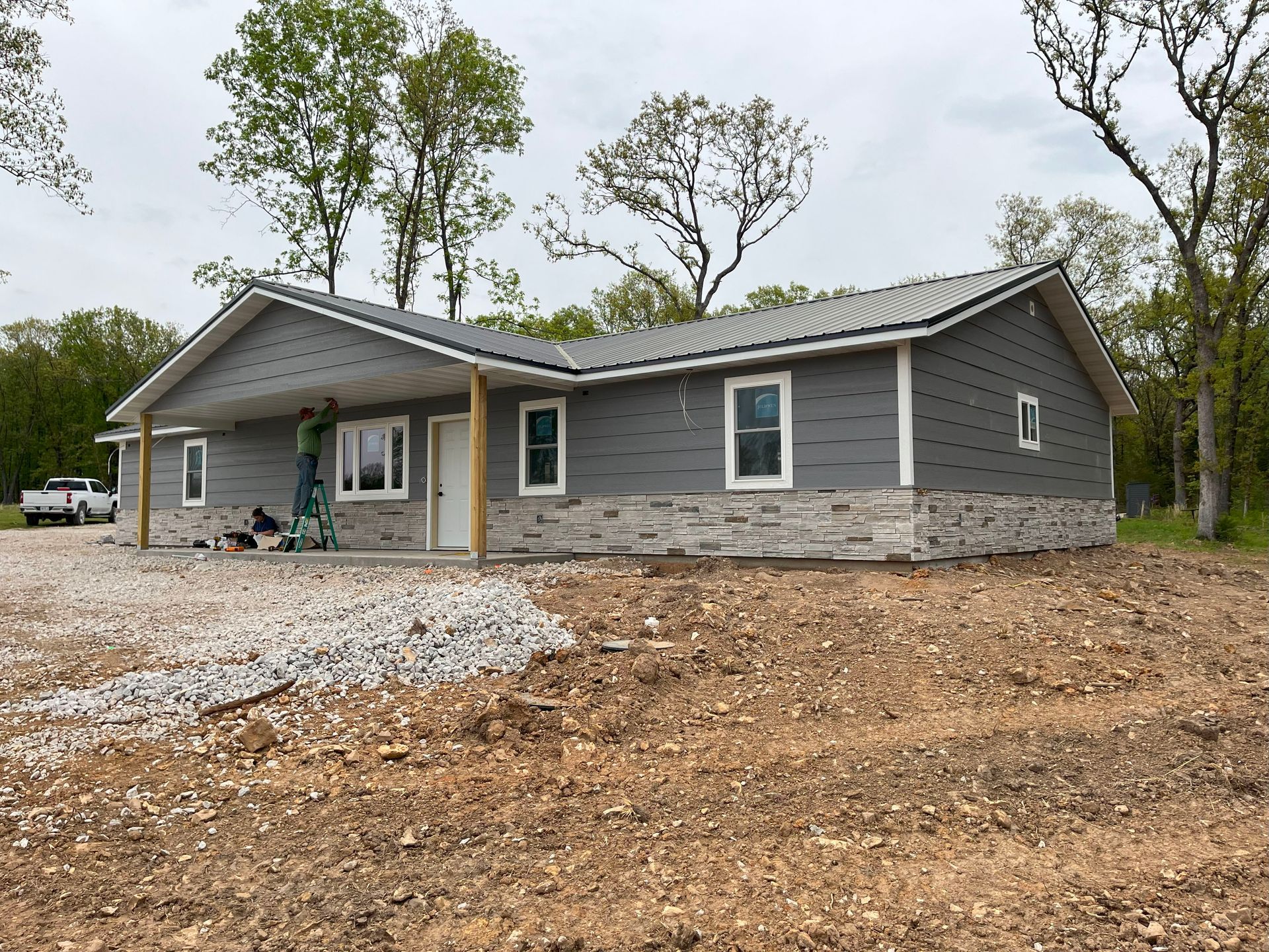 A house is being built in the middle of a dirt field.