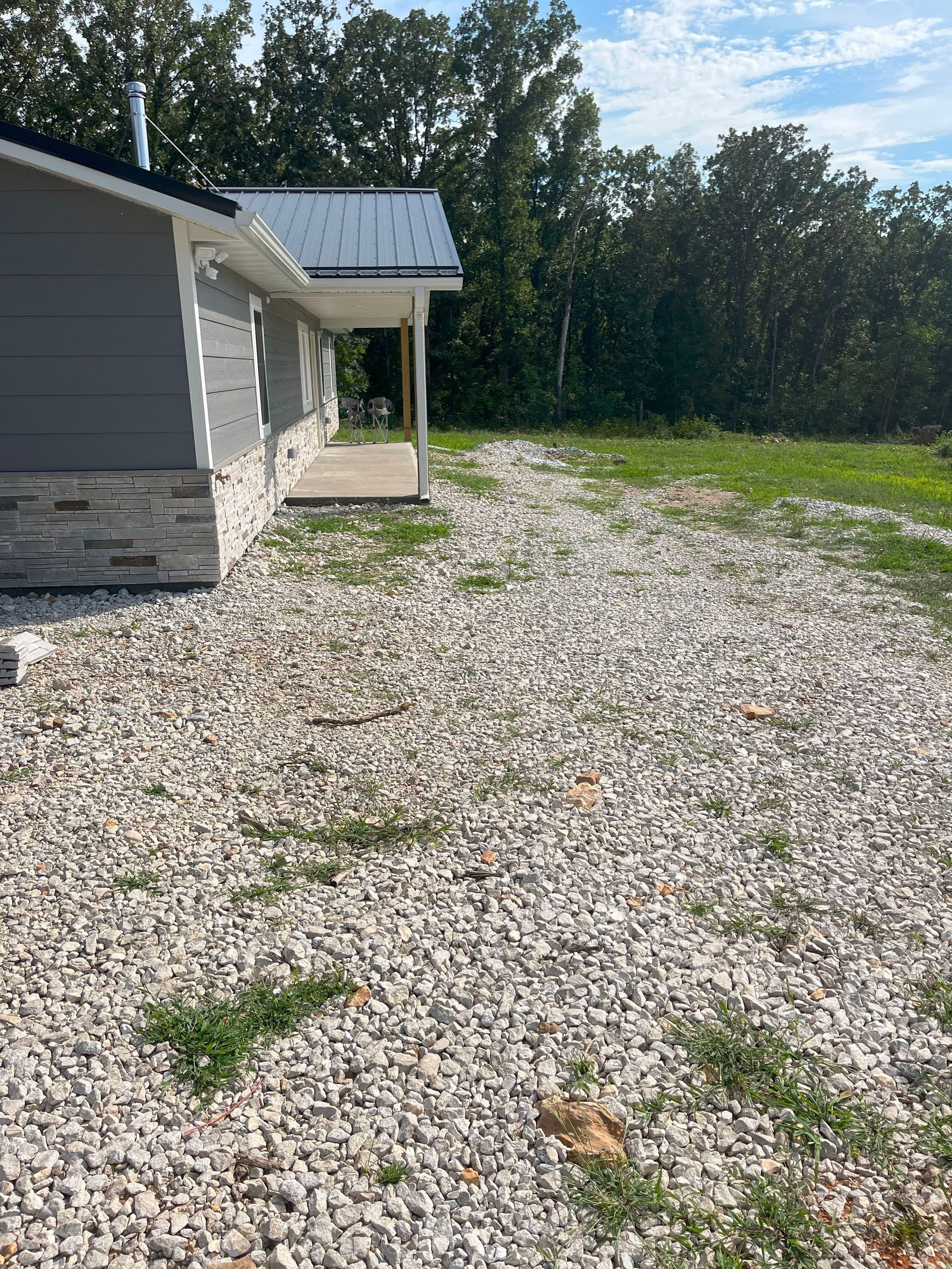 A house with a gravel driveway in front of it.