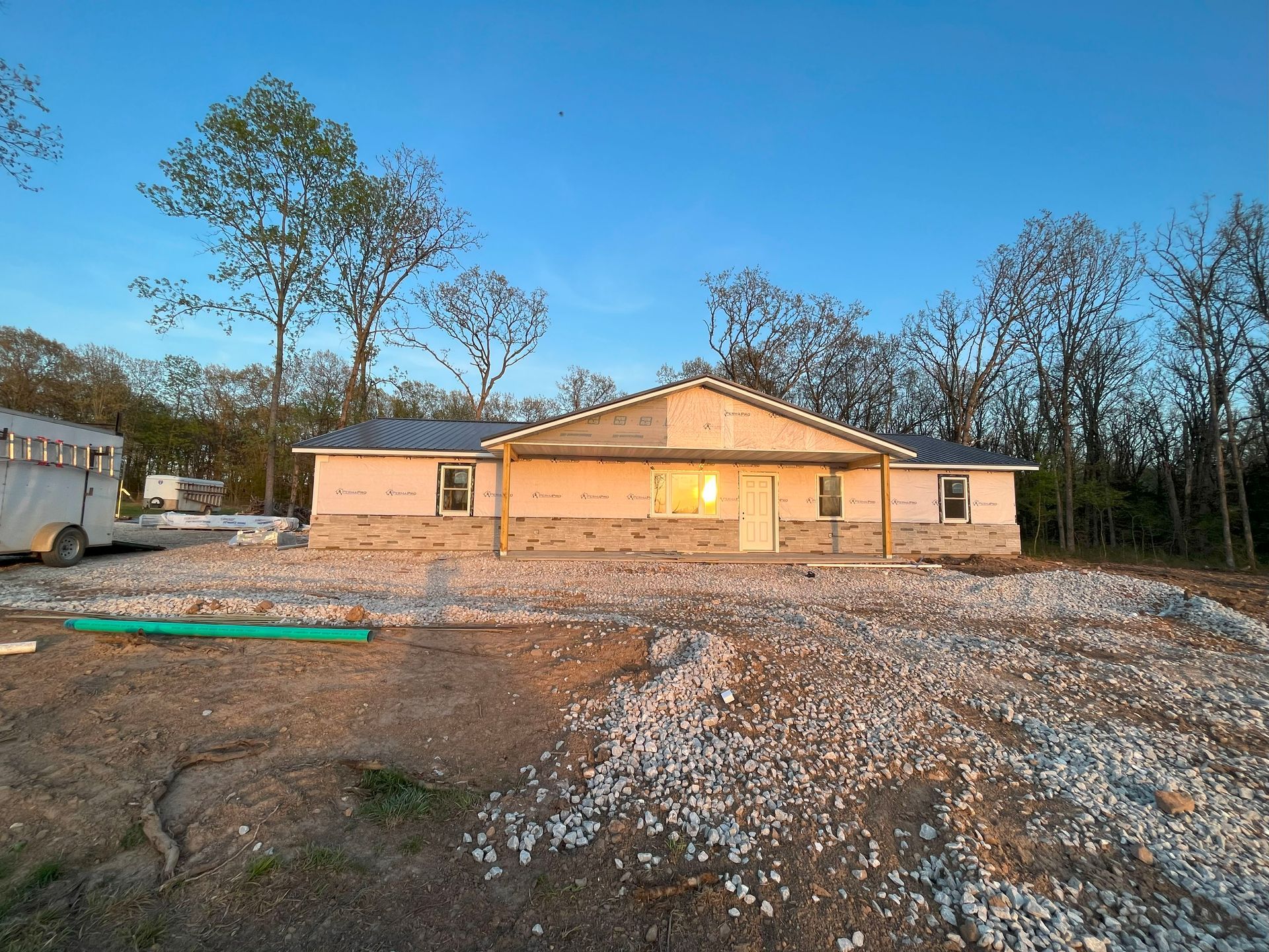 A house that is being built with a school bus parked in front of it