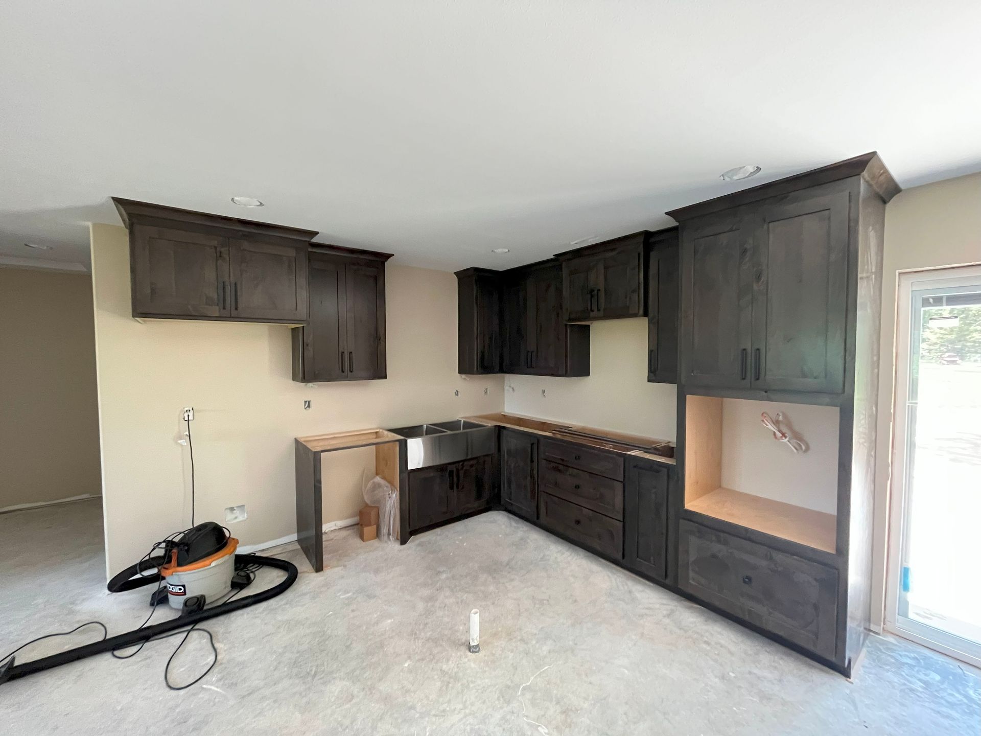 A kitchen under construction with a vacuum cleaner in the middle of the room.