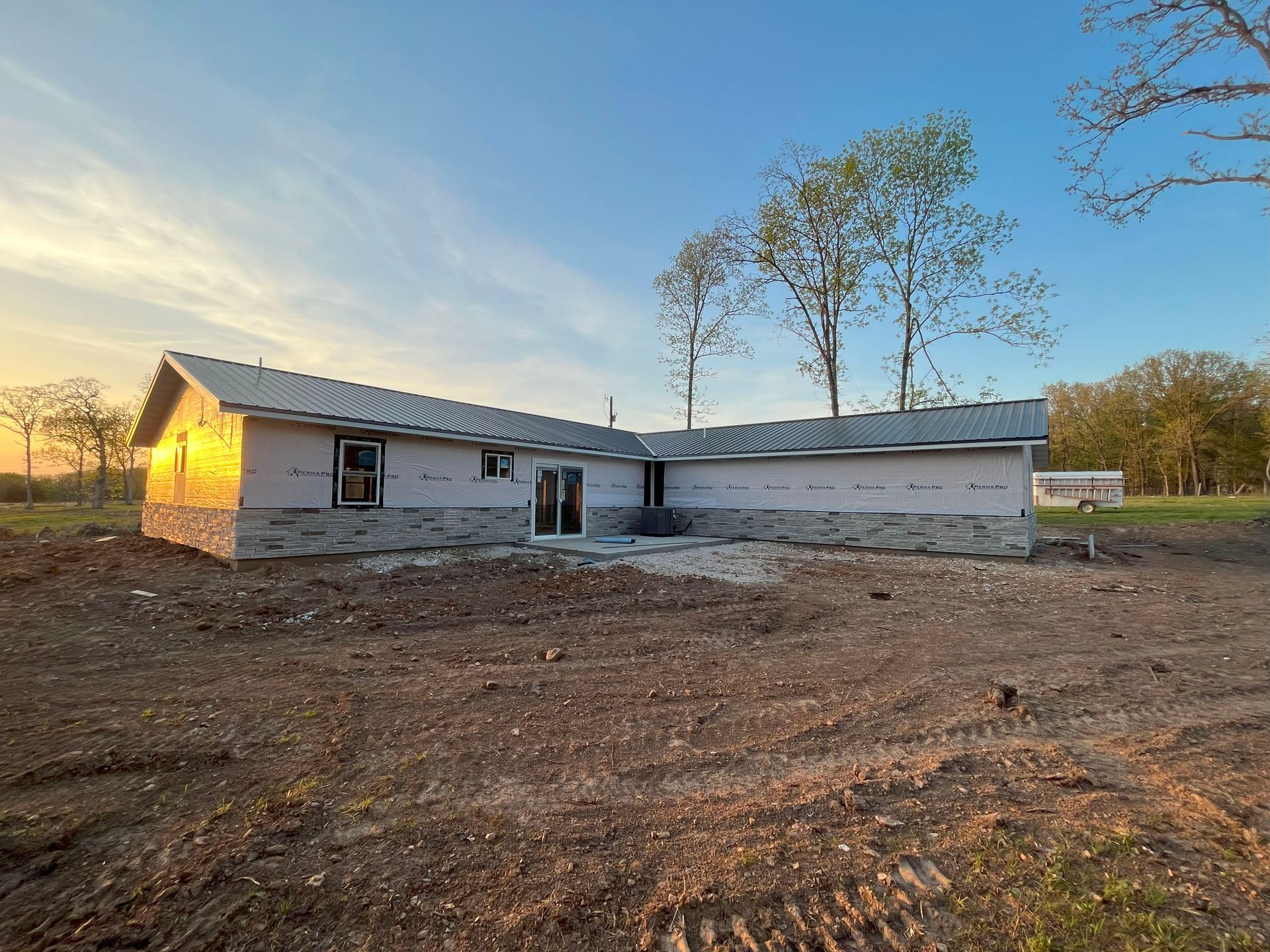 A house is being built in the middle of a dirt field.
