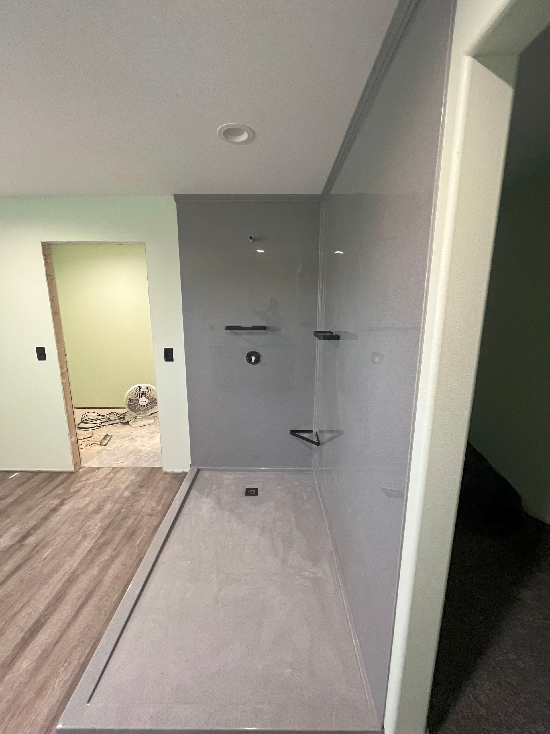 A bathroom with a walk in shower and a door.