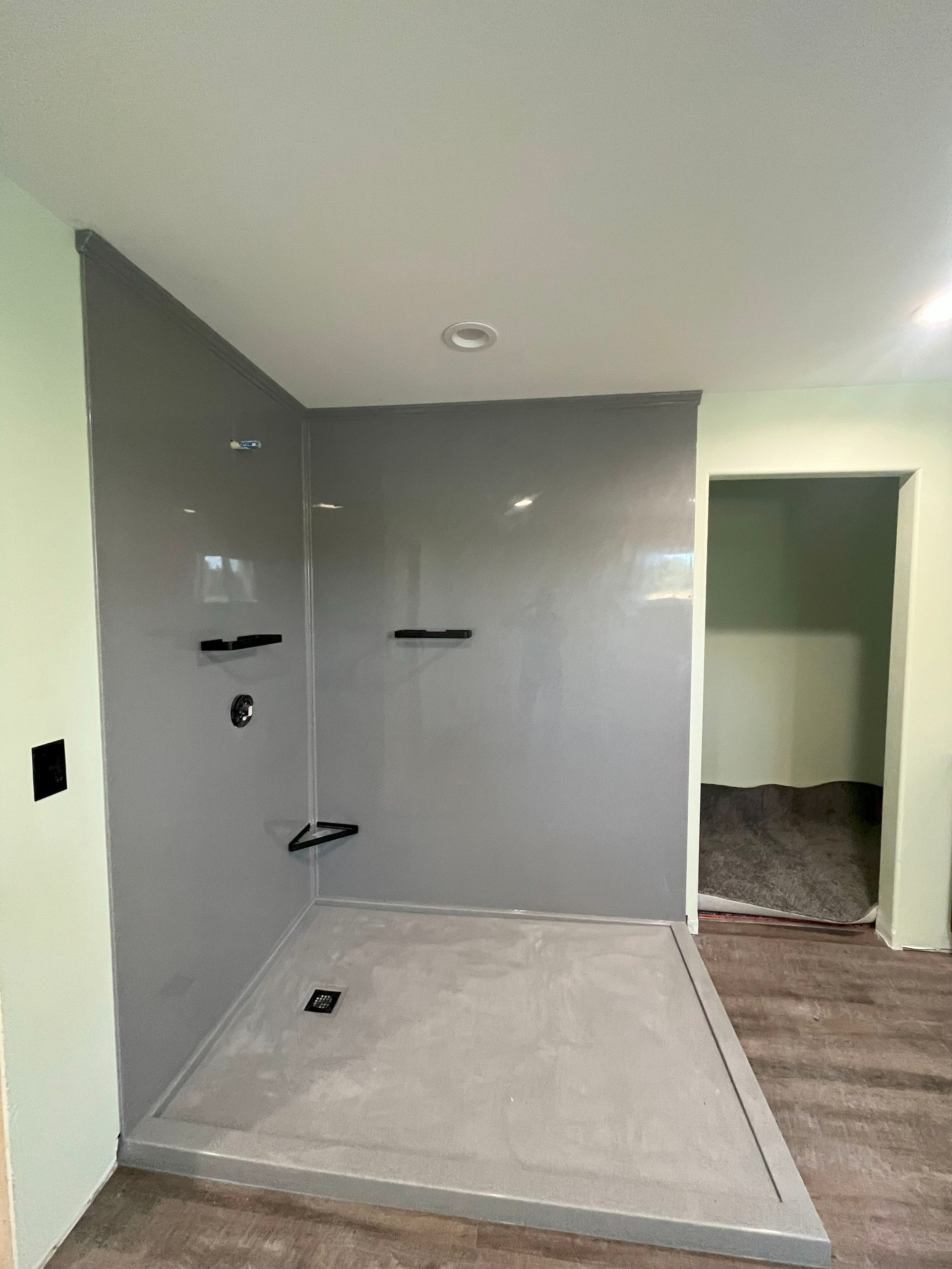 A bathroom with a walk in shower and a door.