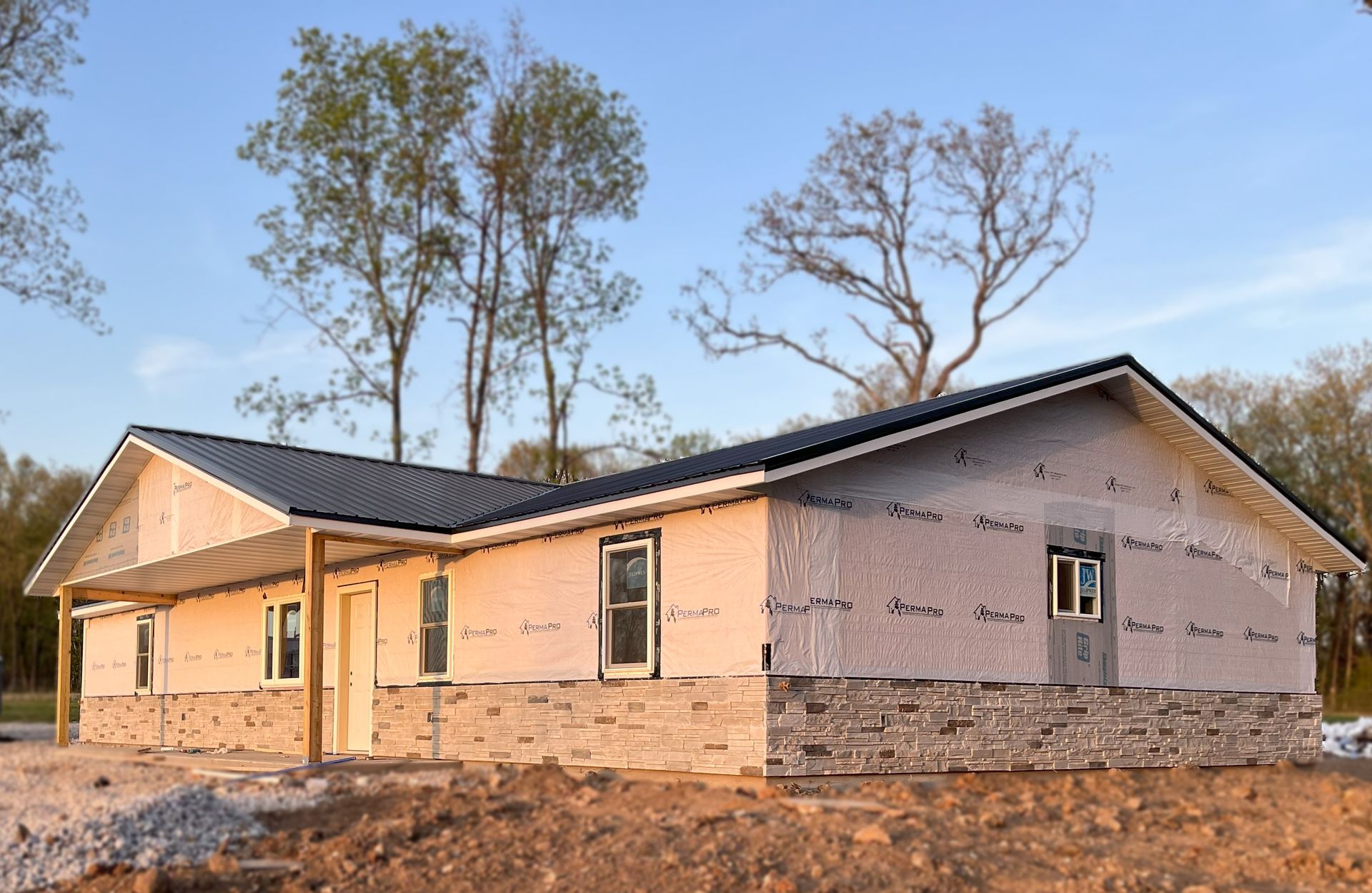 A house is being built on a hill with trees in the background.