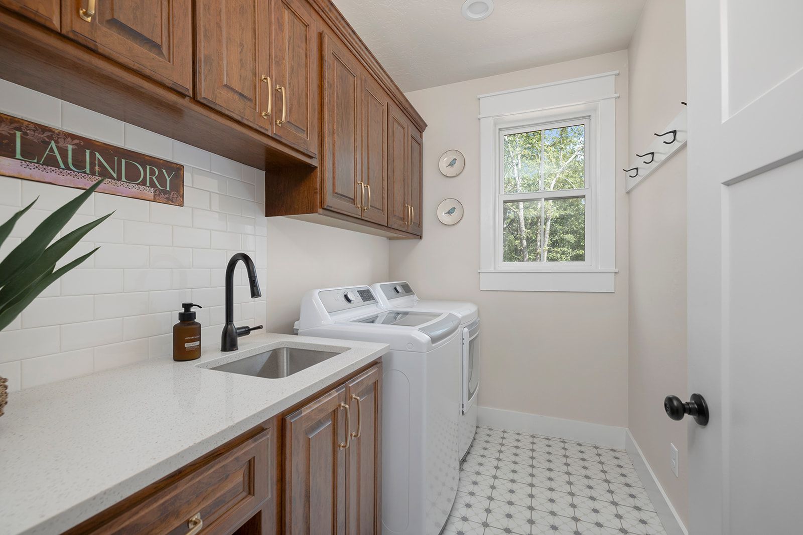 A laundry room with a washer and dryer , sink , and window.