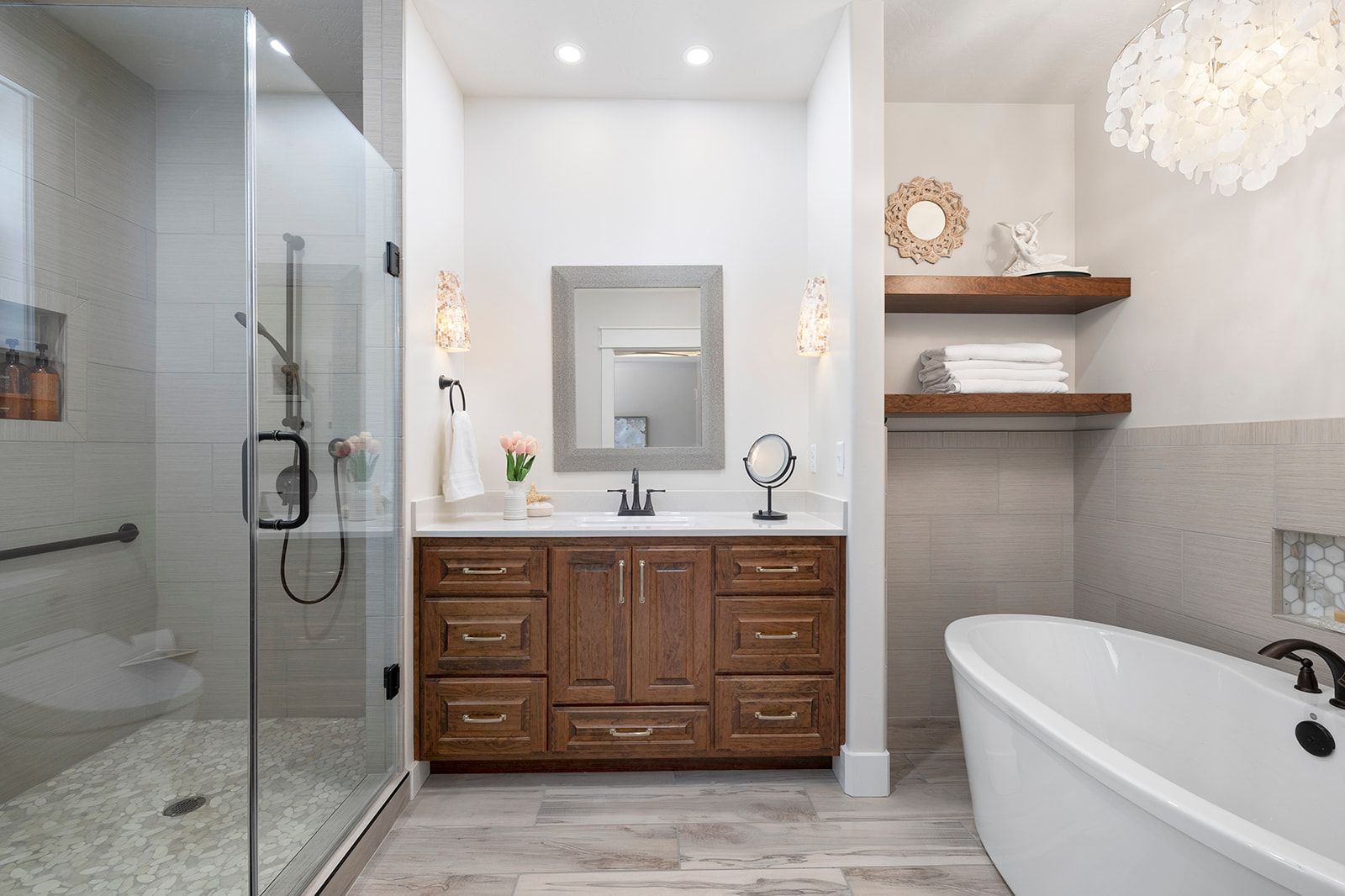 A bathroom with a tub , sink , mirror and walk in shower.