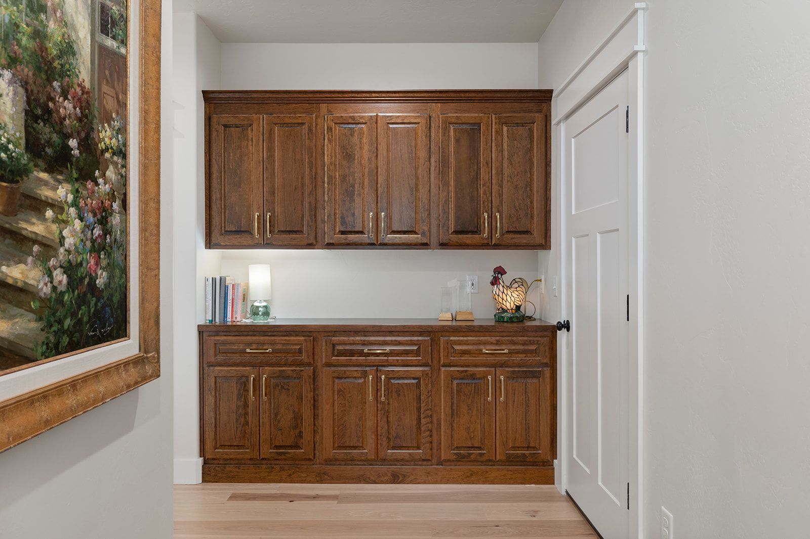 A kitchen with wooden cabinets and a painting on the wall.