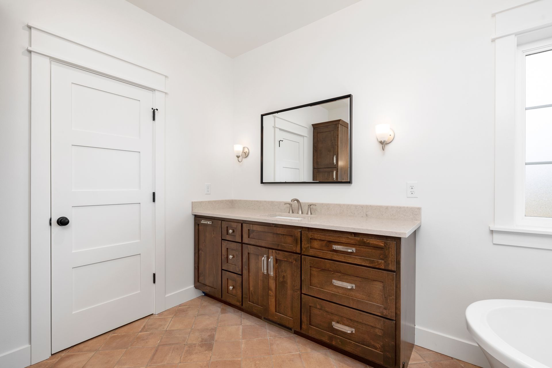 A bathroom with two sinks , a mirror and a tub.