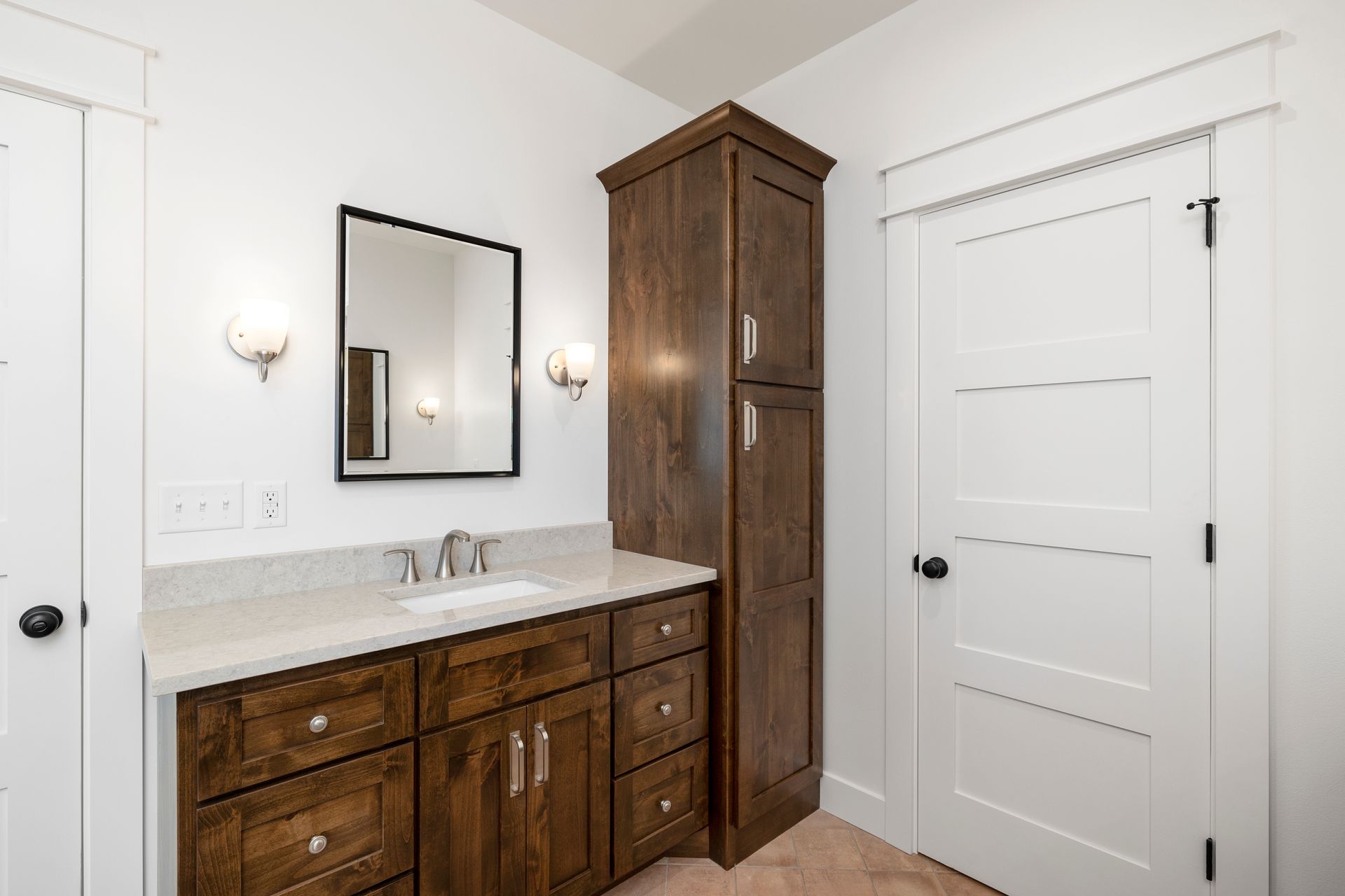 A bathroom with a sink , mirror and cabinets.