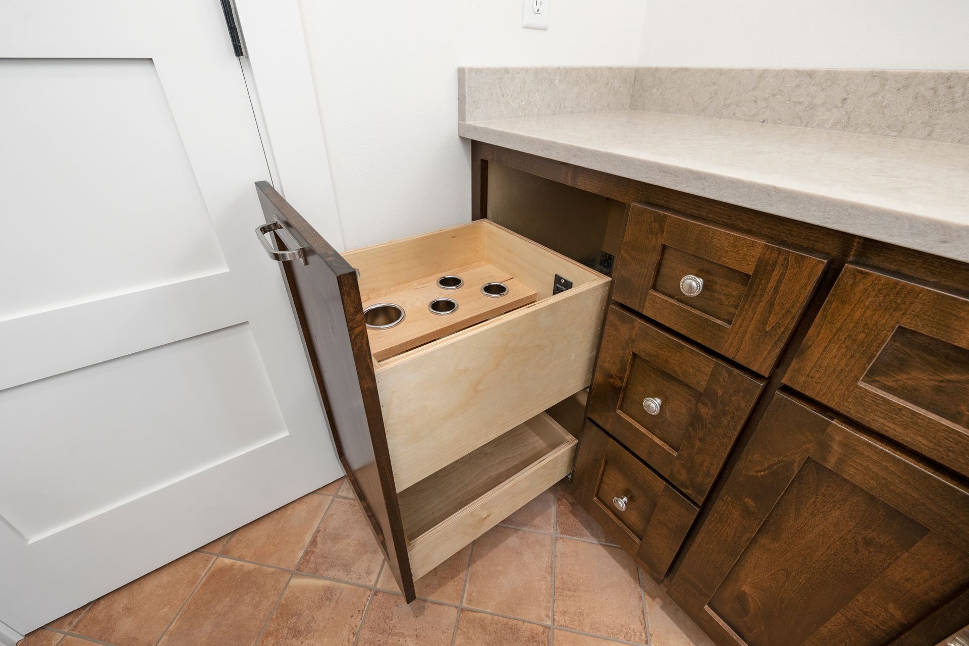 A bathroom vanity with a drawer open and a door open.