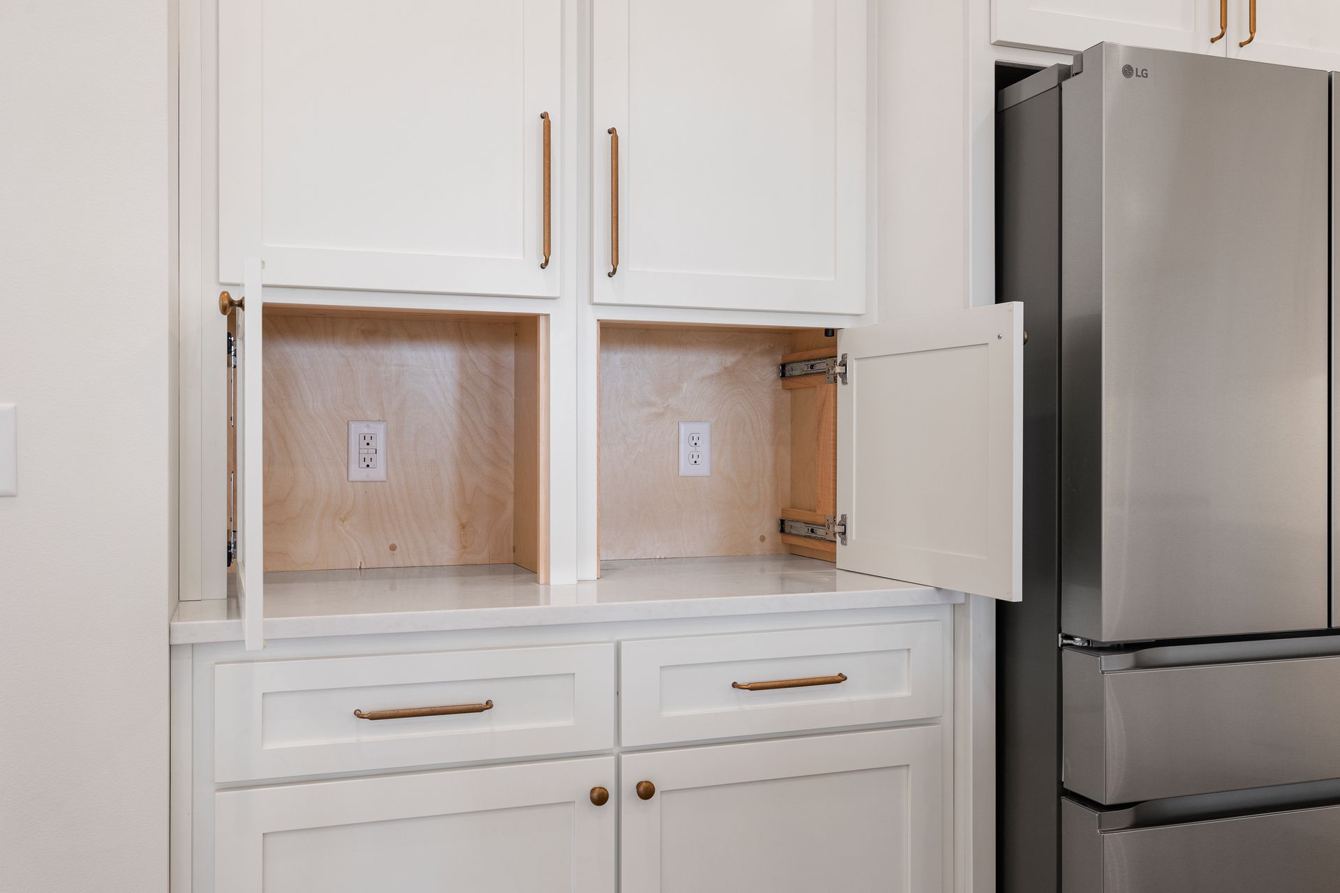A kitchen with white cabinets and a stainless steel refrigerator.