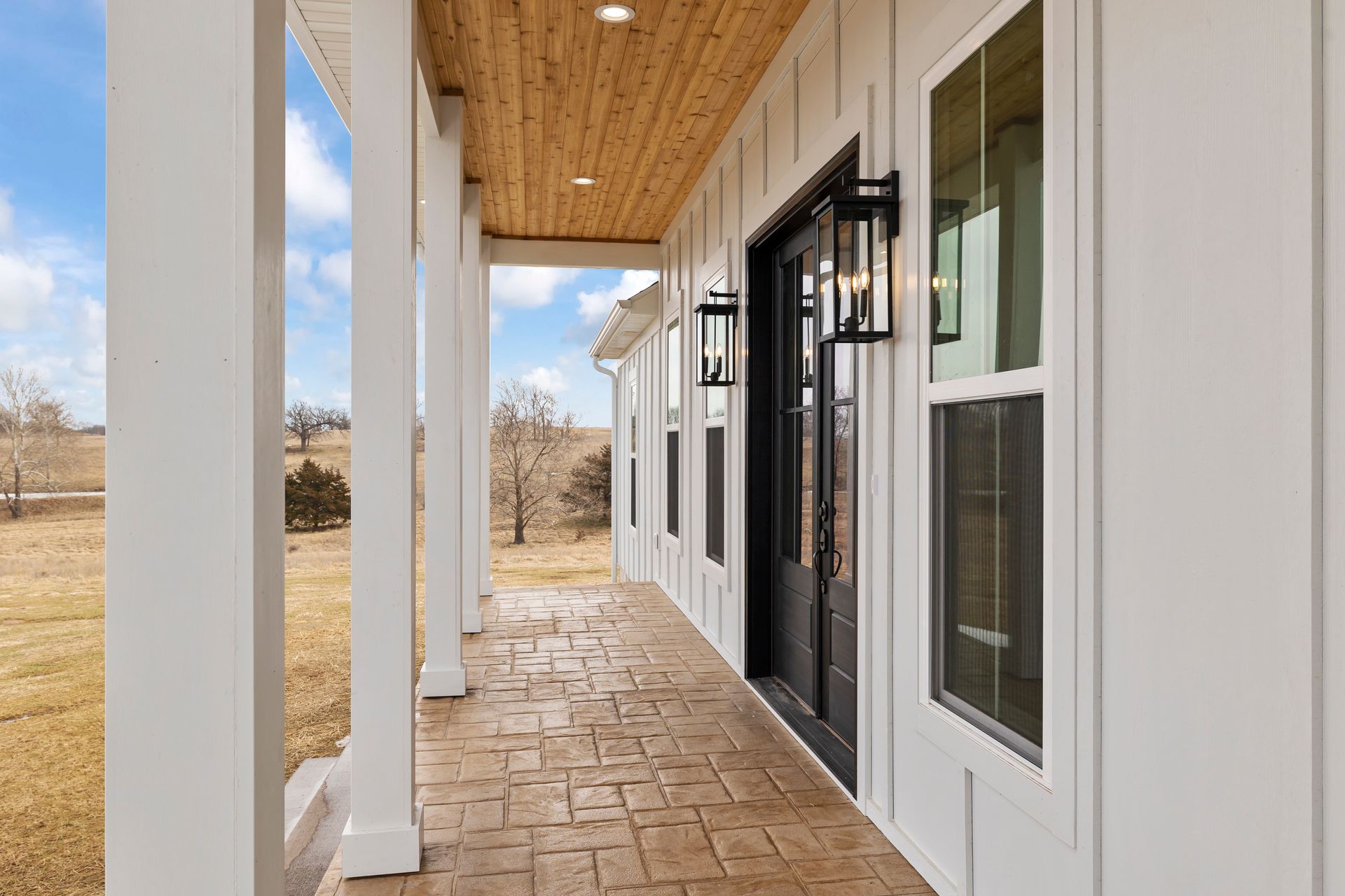 A white house with a porch and a black door.