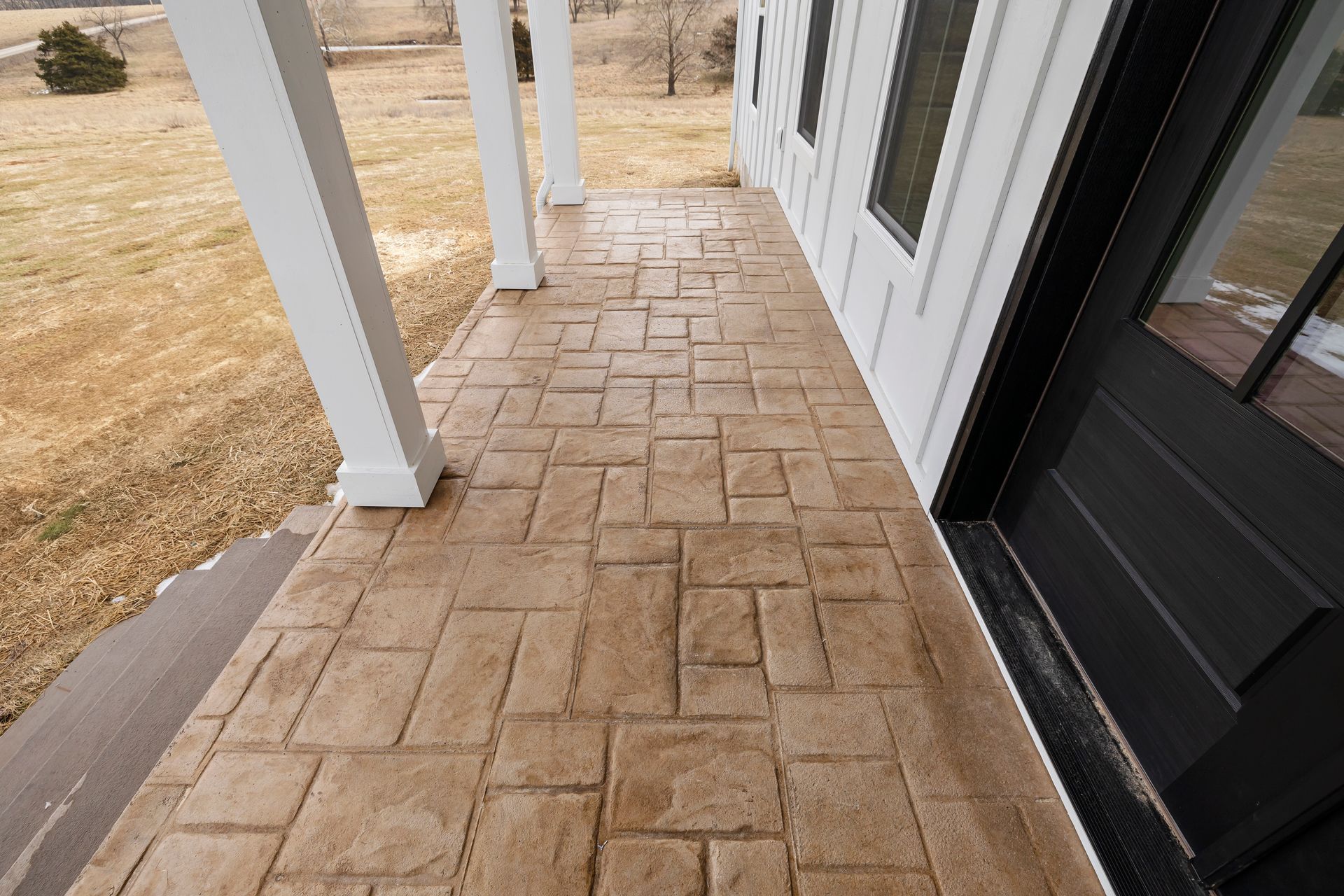 A concrete walkway leading to the front door of a house.