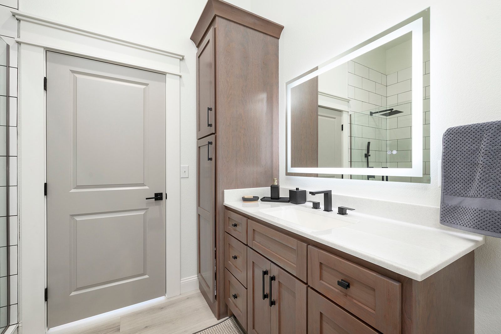 A bathroom with a sink , mirror and cabinets.