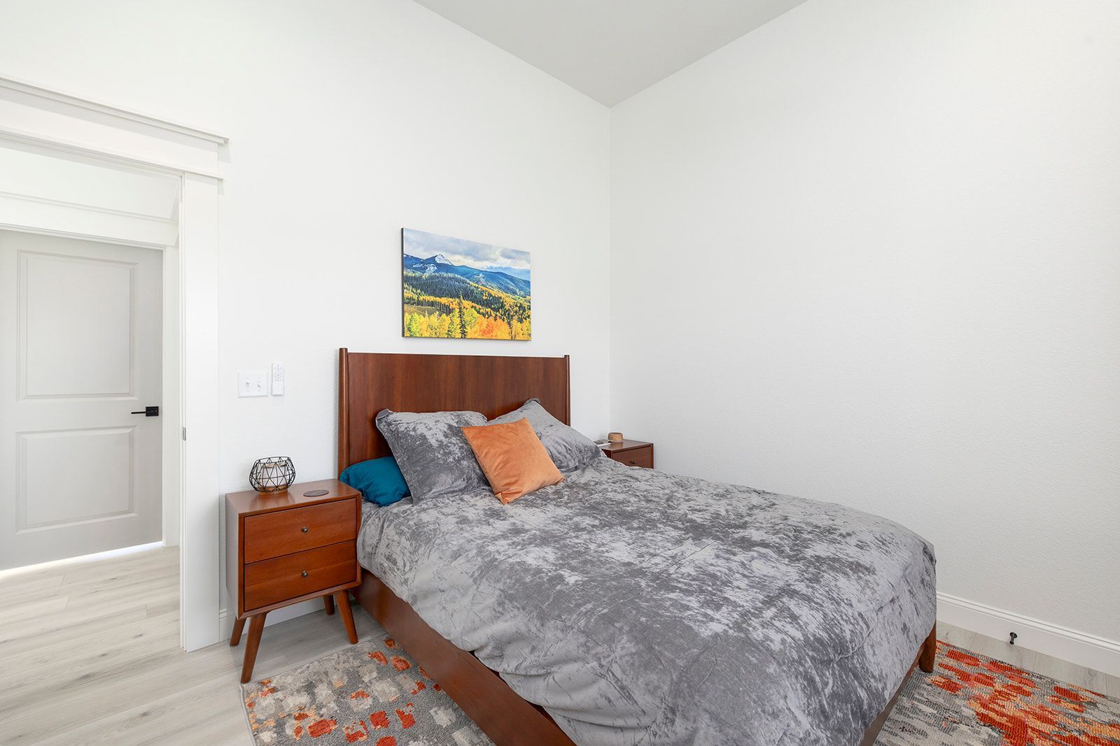 A bedroom with a bed , nightstand , and rug.