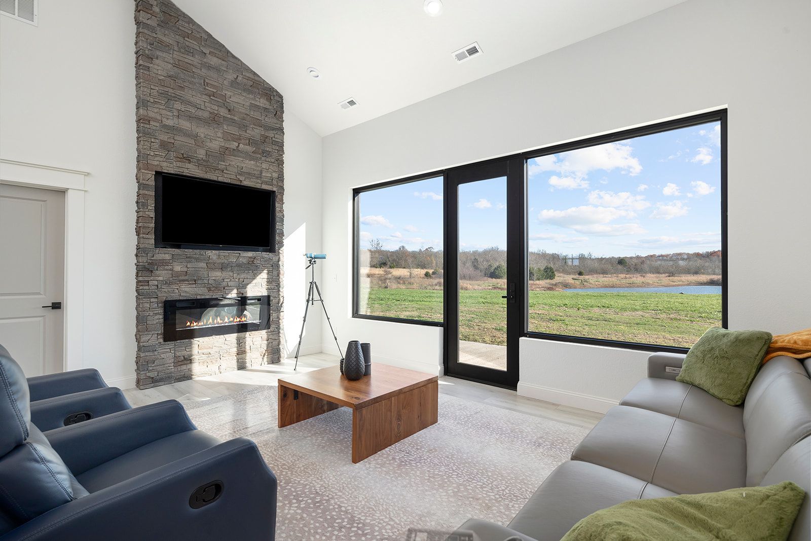 A living room with a couch , chairs , coffee table and television.
