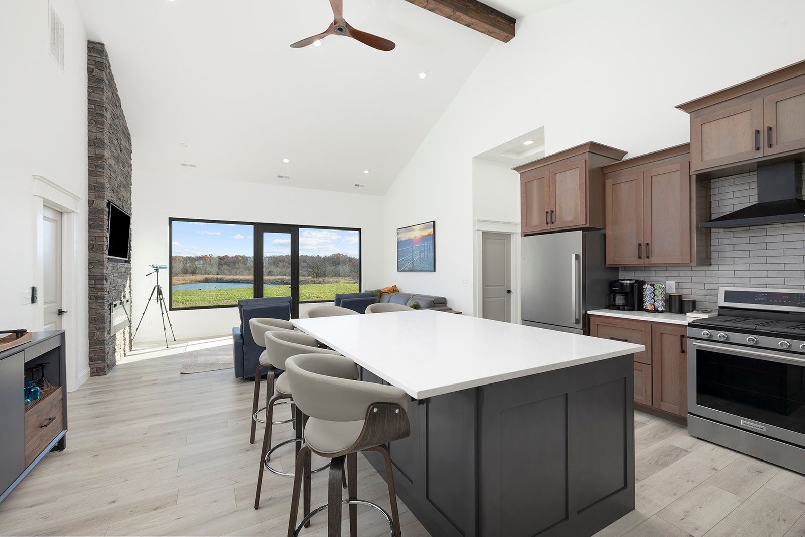A kitchen with a large island in the middle and a ceiling fan.