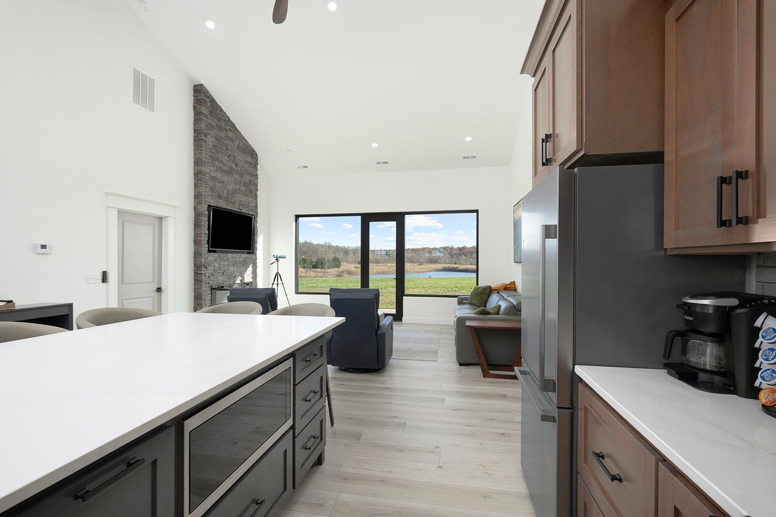 A kitchen with a large island and a stainless steel refrigerator.