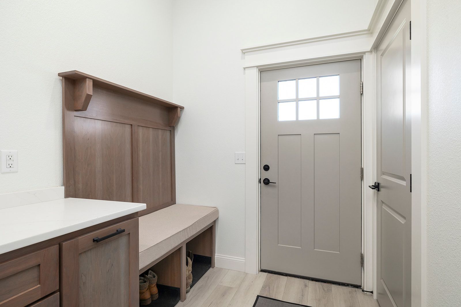 A hallway with a bench and a door in a house.