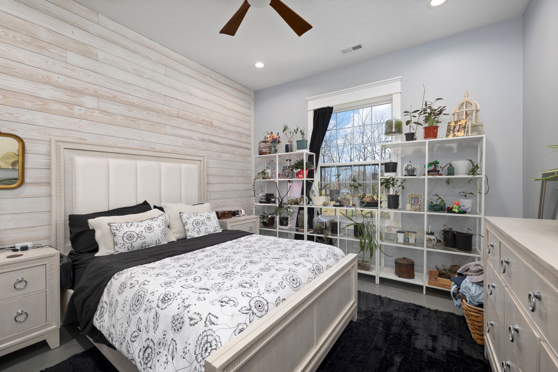 A bedroom with a large bed and a ceiling fan