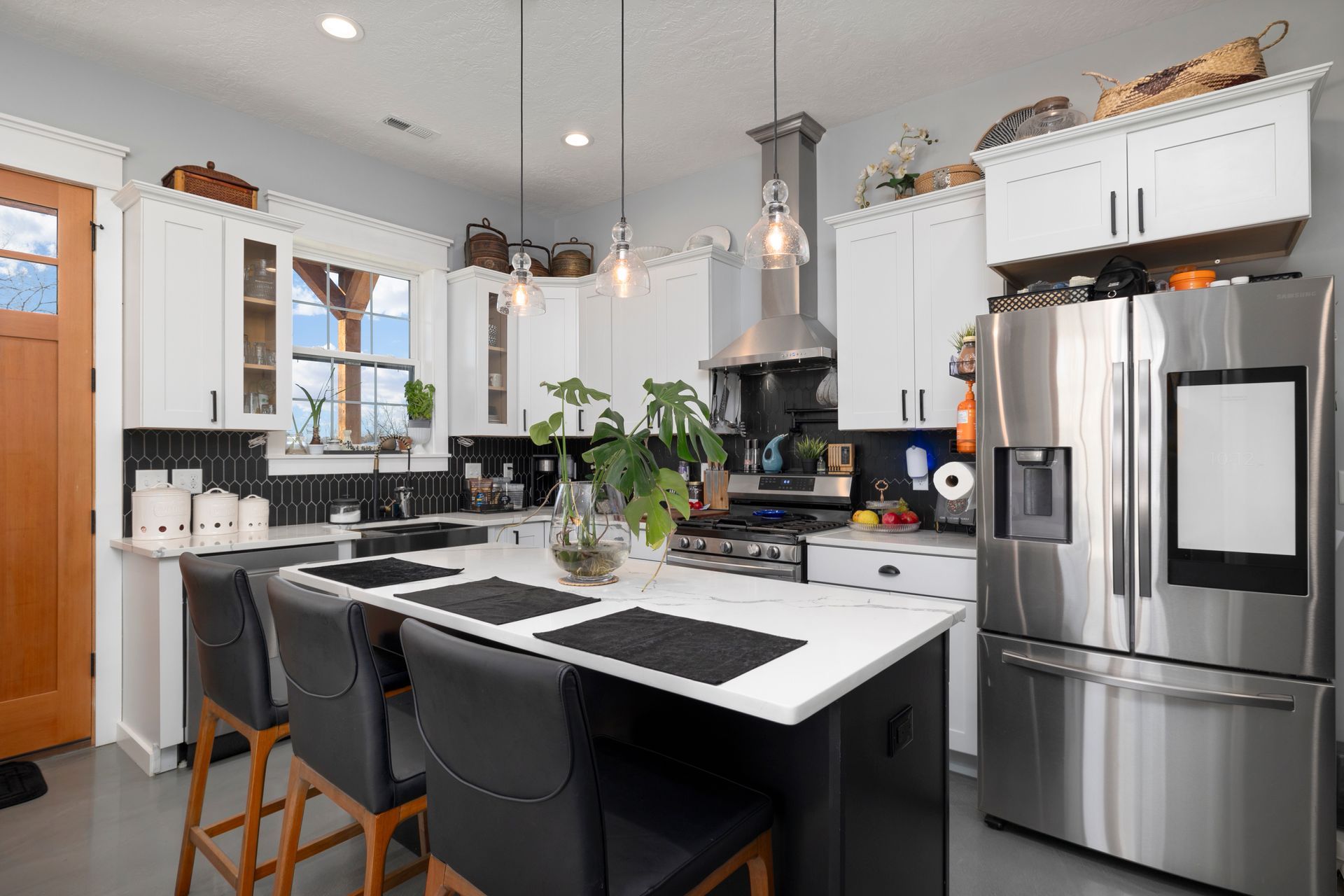 A kitchen with stainless steel appliances and white cabinets.