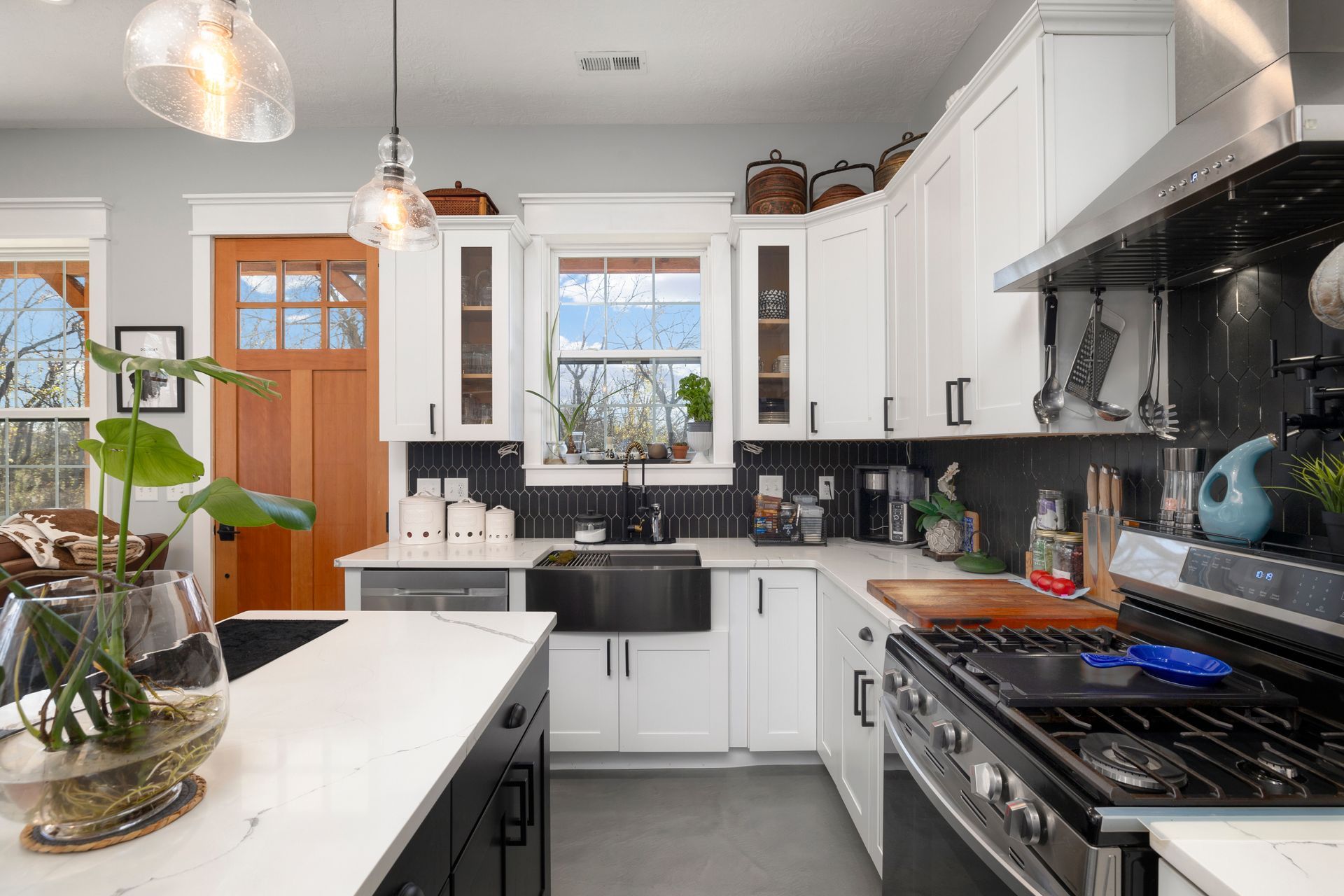 A kitchen with white cabinets , stainless steel appliances , a sink , and a stove.