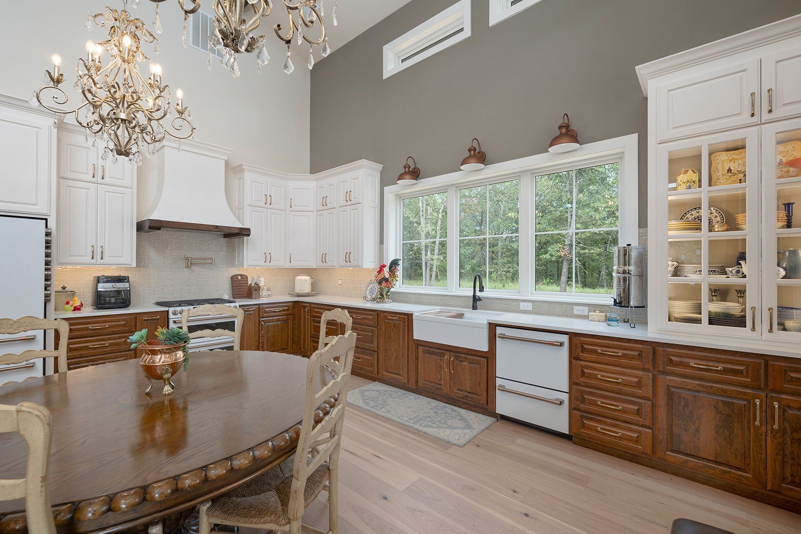 A kitchen with a table and chairs and a chandelier.