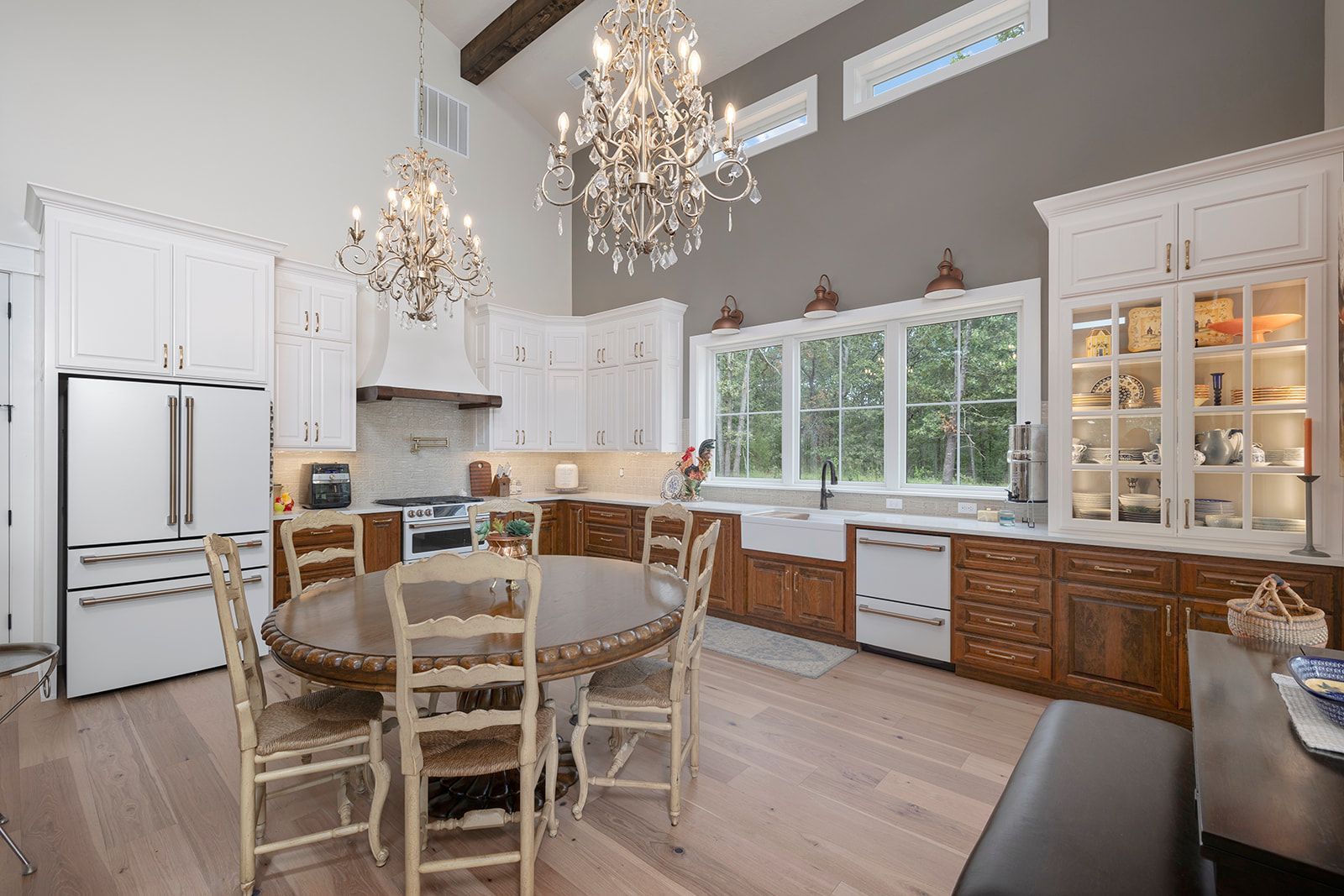A kitchen with a round table and chairs and a chandelier hanging from the ceiling.