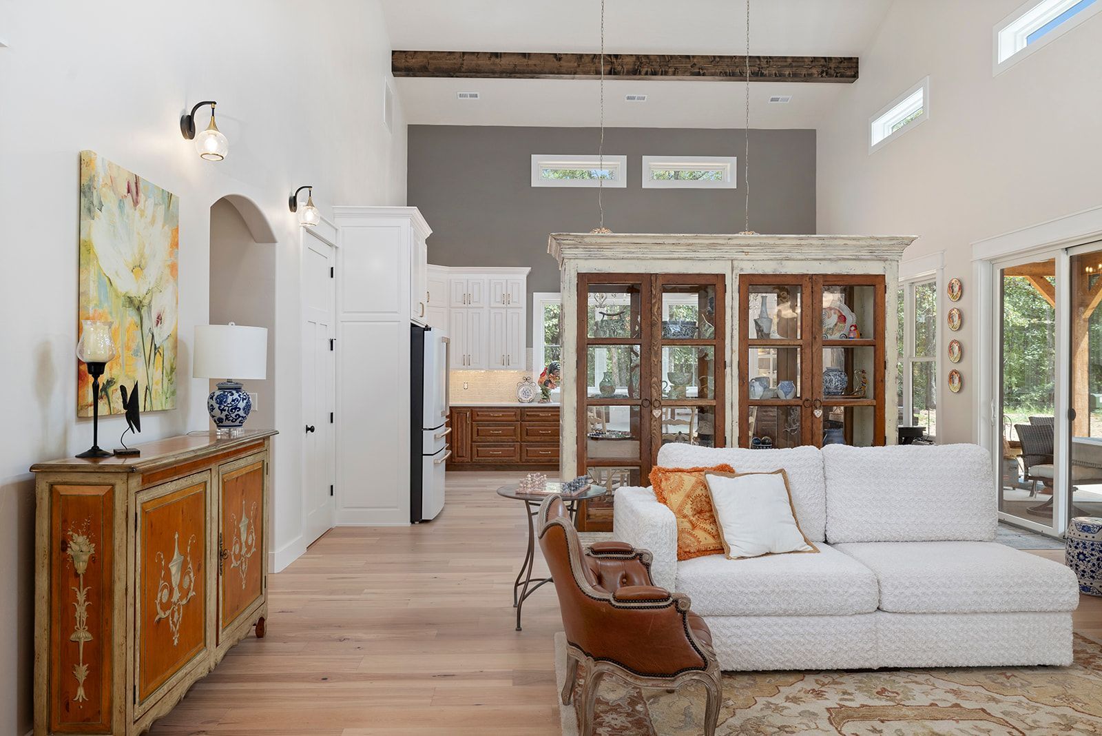 A living room with a white couch and a brown chair.